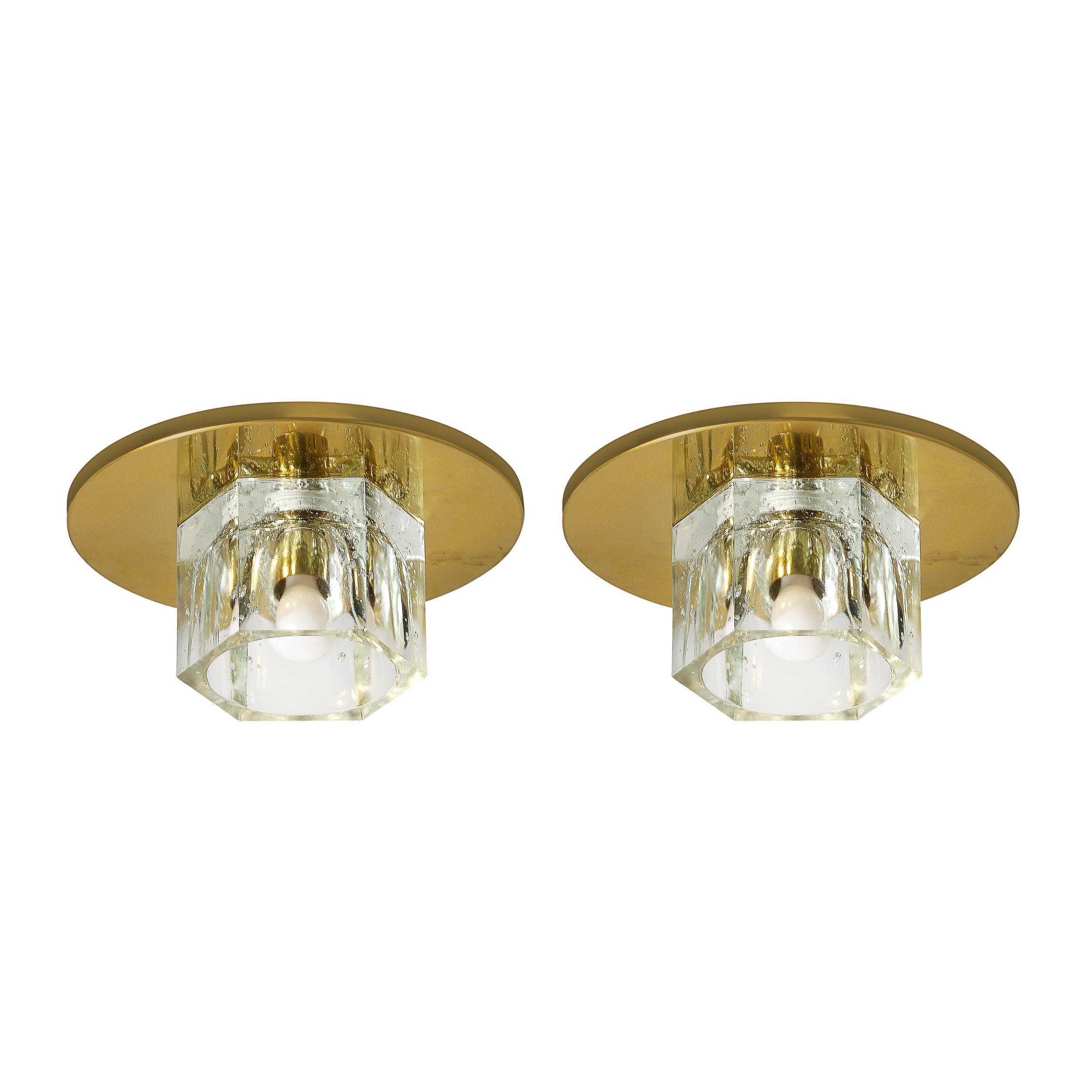 

This lovely Pair of Mid-Century Modernist Hexagonal Shade Glass Flush Mount Chandeliers W/Brass Fittings is by Lightolier and originates from the United States, Circa 1970. Features a hexagonal glass shade which house and diffuse the light of the