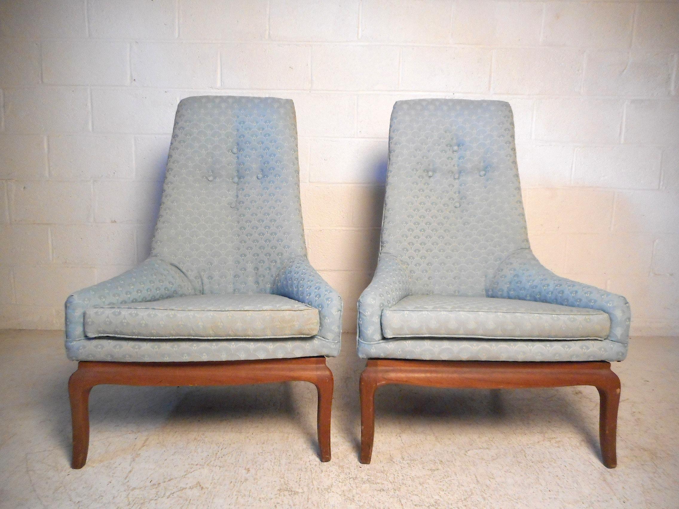 This stylish pair of midcentury chairs feature high tapered backrests with tufted upholstery, sturdy wooden bases with splayed back legs, and a vintage sky blue upholstery. Styled after Adrian Pearsall, these chairs will make an impression in any