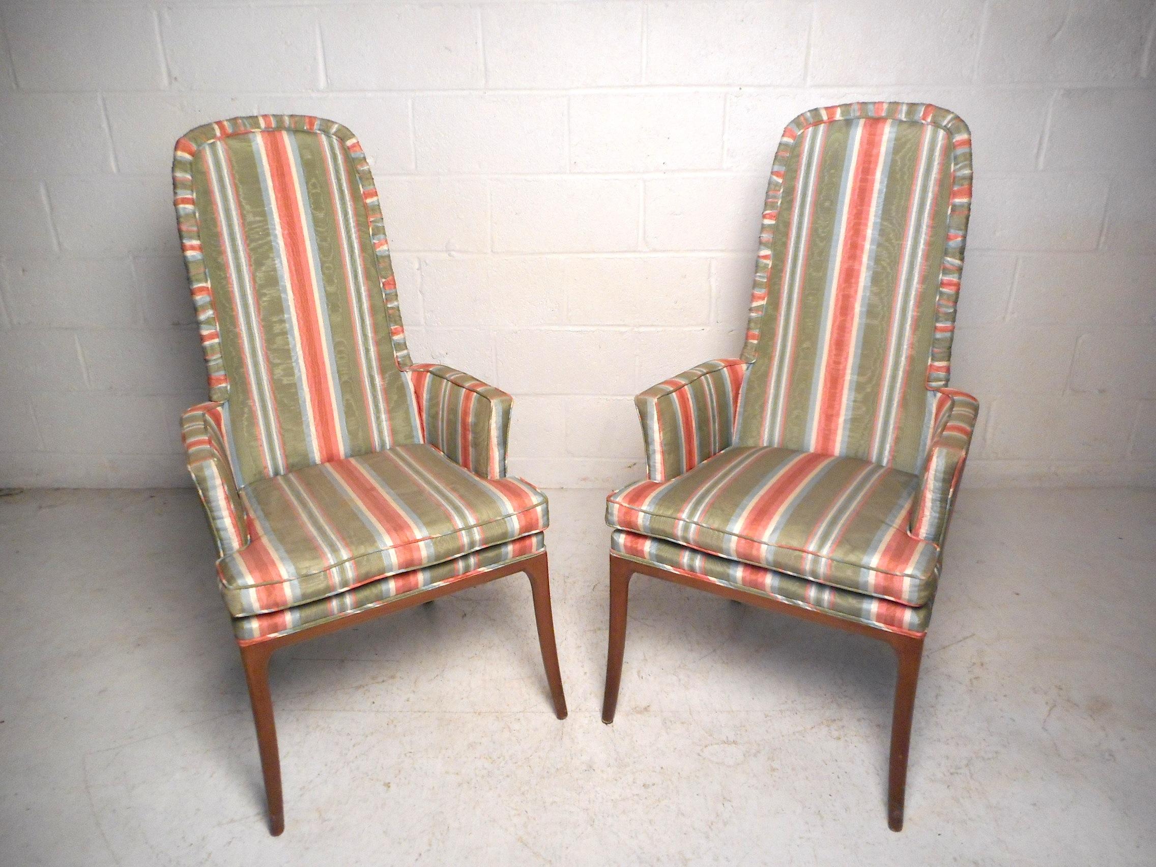 This impressive pair of midcentury chairs feature a vintage striped upholstery and sturdy wooden frames with sleekly splayed legs. This pair would make a great addition to any modern interior's seating arrangement. Please confirm item location with