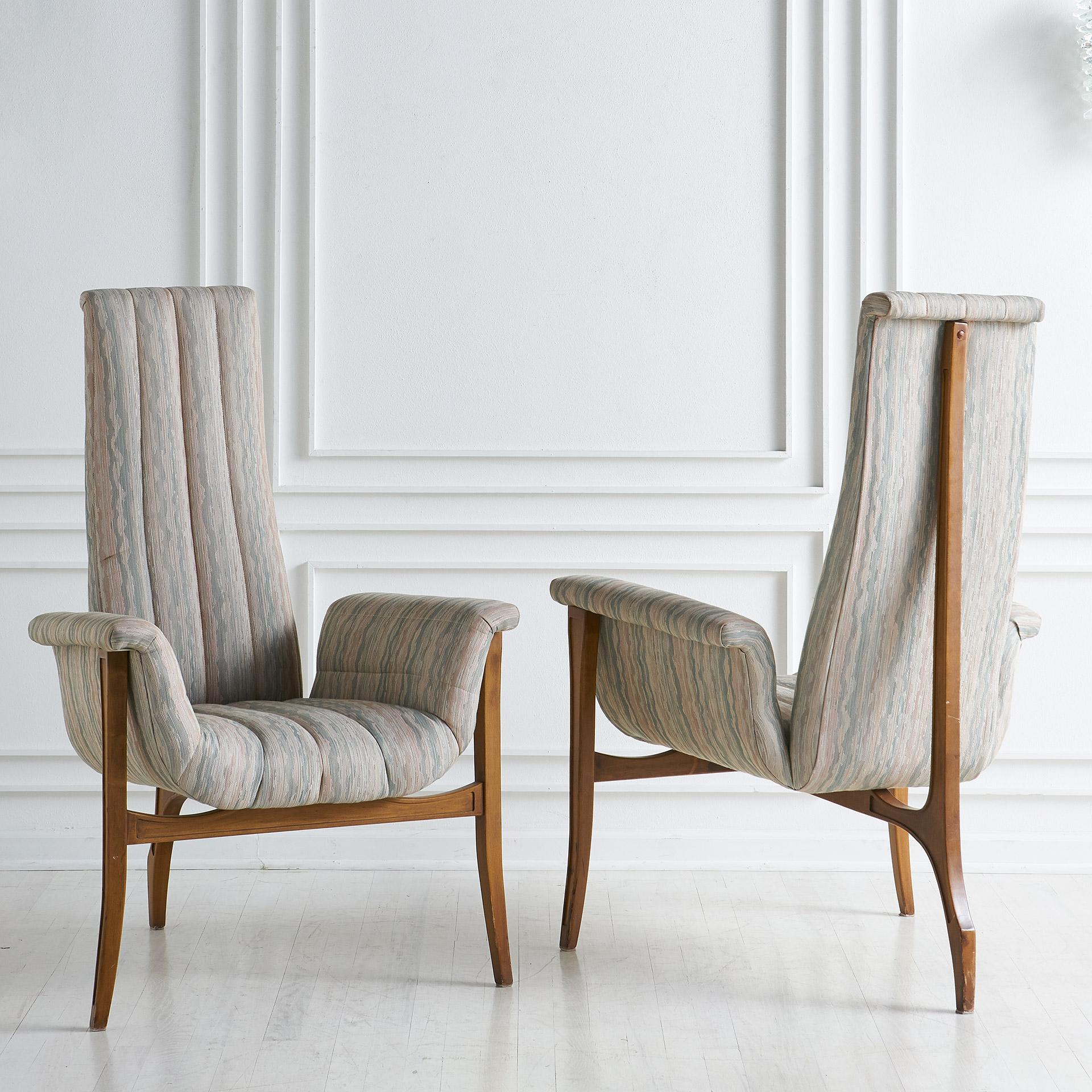 A sculptural pair of midcentury accent chairs featuring a 3 leg design, channeled upholstery, flared arms, and tall back.