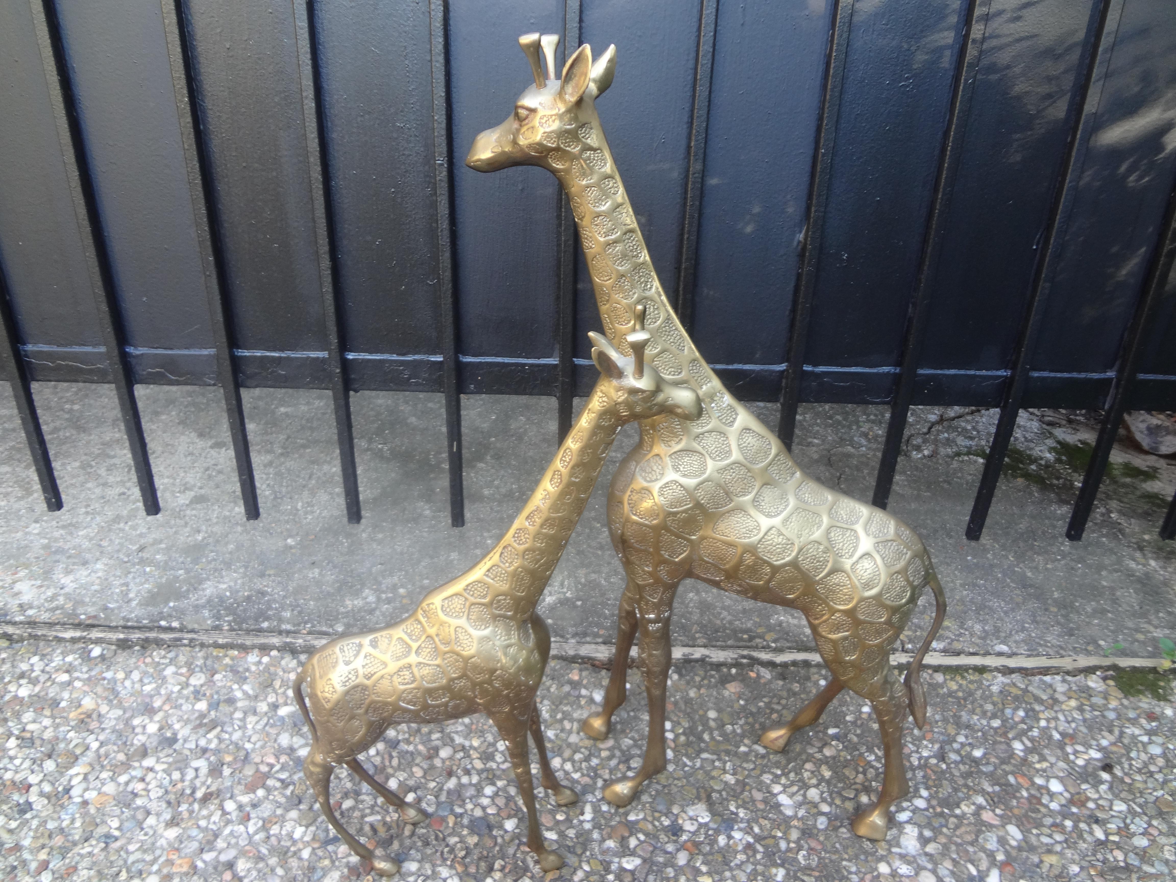Pair of midcentury Hollywood Regency brass giraffe statues or sculptures. The pair consists of a taller male-23 inches H, 18 inches L and 3.5 inches W. Female-17.5 inches H, 12.5 inches L and 3.5 inches D. great patina!
