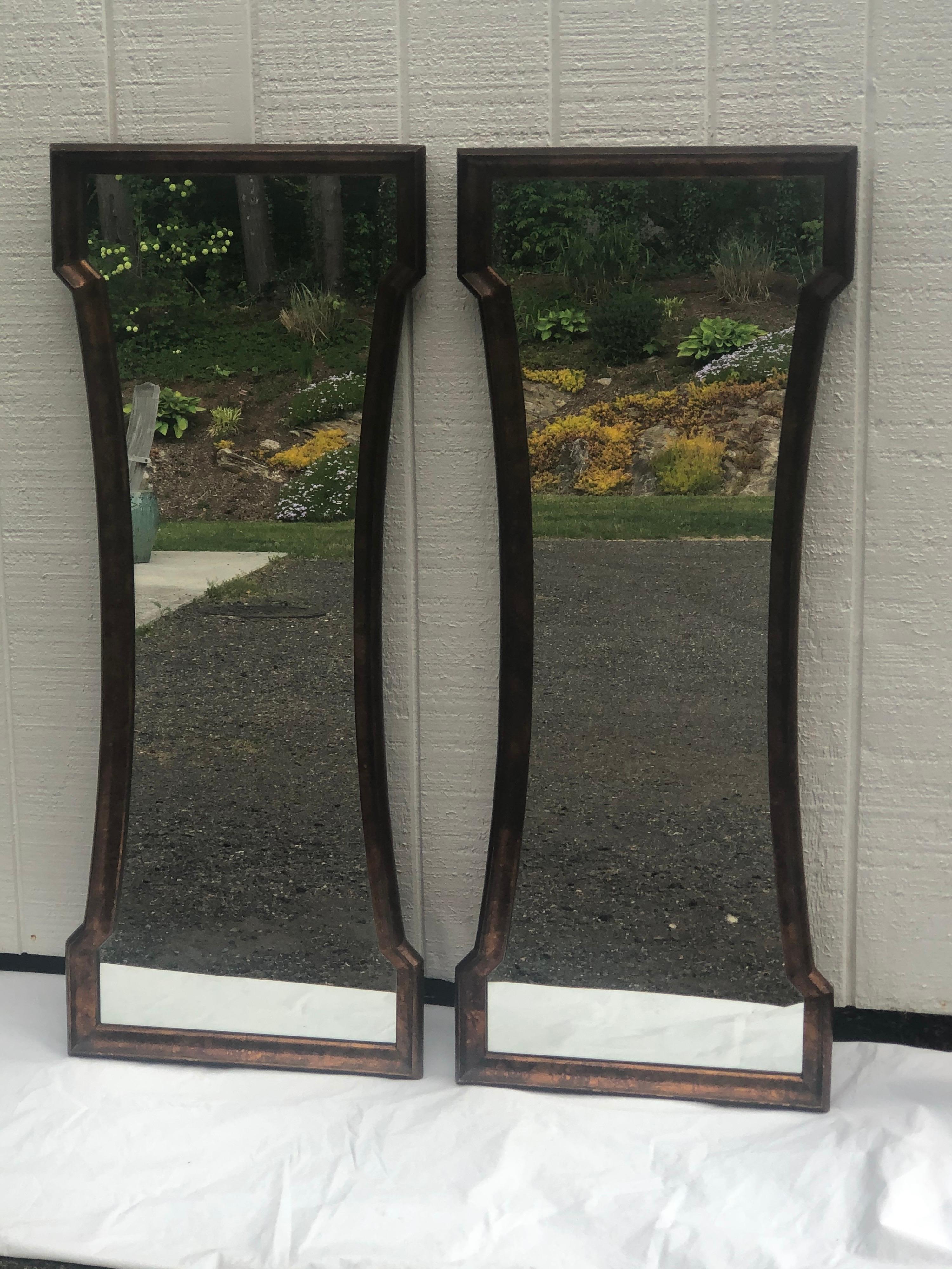 Pair of Mid Century hour glass mirrors attributed to Weiman. Classic oil drip tortoiseshell finish. These dramatic keyhole shaped mirrors could be used above a Dual vanity in a bathroom or entryway in a hall. They would look amazing against a busy