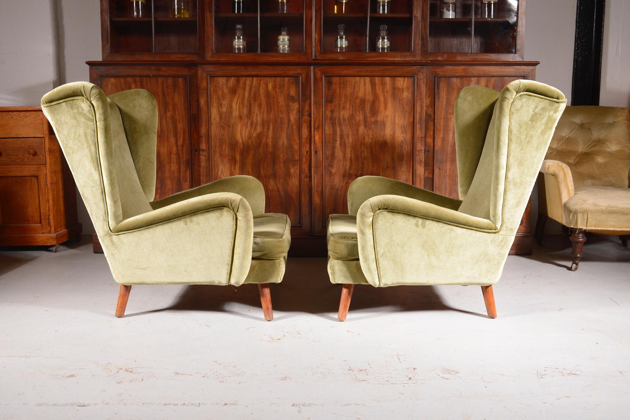 A super stylish and very comfy pair of Howard Keith ‘Fanfare’ wingback armchairs, with green velvet upholstery, on turned tapered legs.