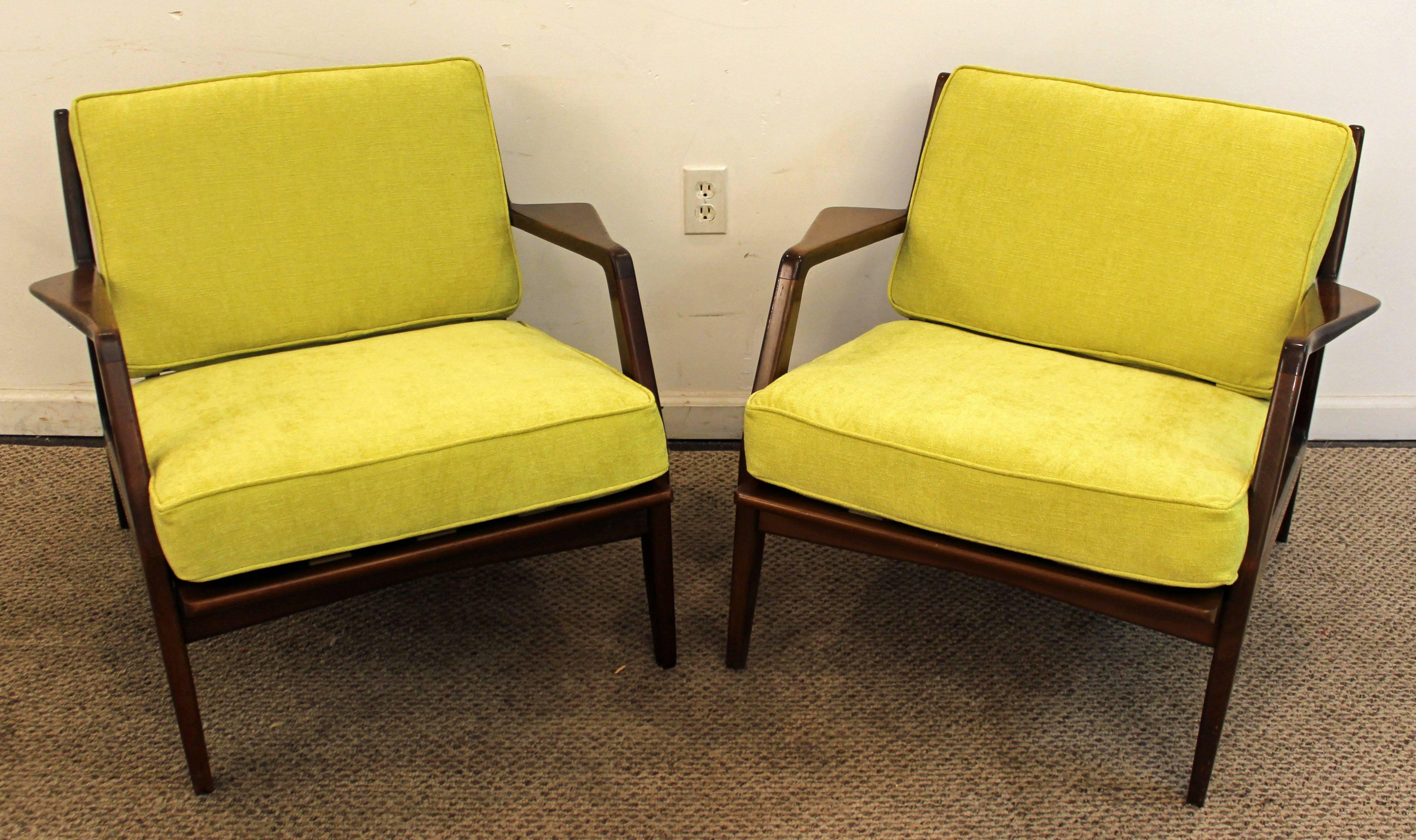 The set includes two open arm walnut lounge or accent chairs. They have been reupholstered with 'citron' fabric. We believe they may be earlier unsigned copies of IB Kofod Larsen chairs, but we are unsure. 

Measures: 30.5