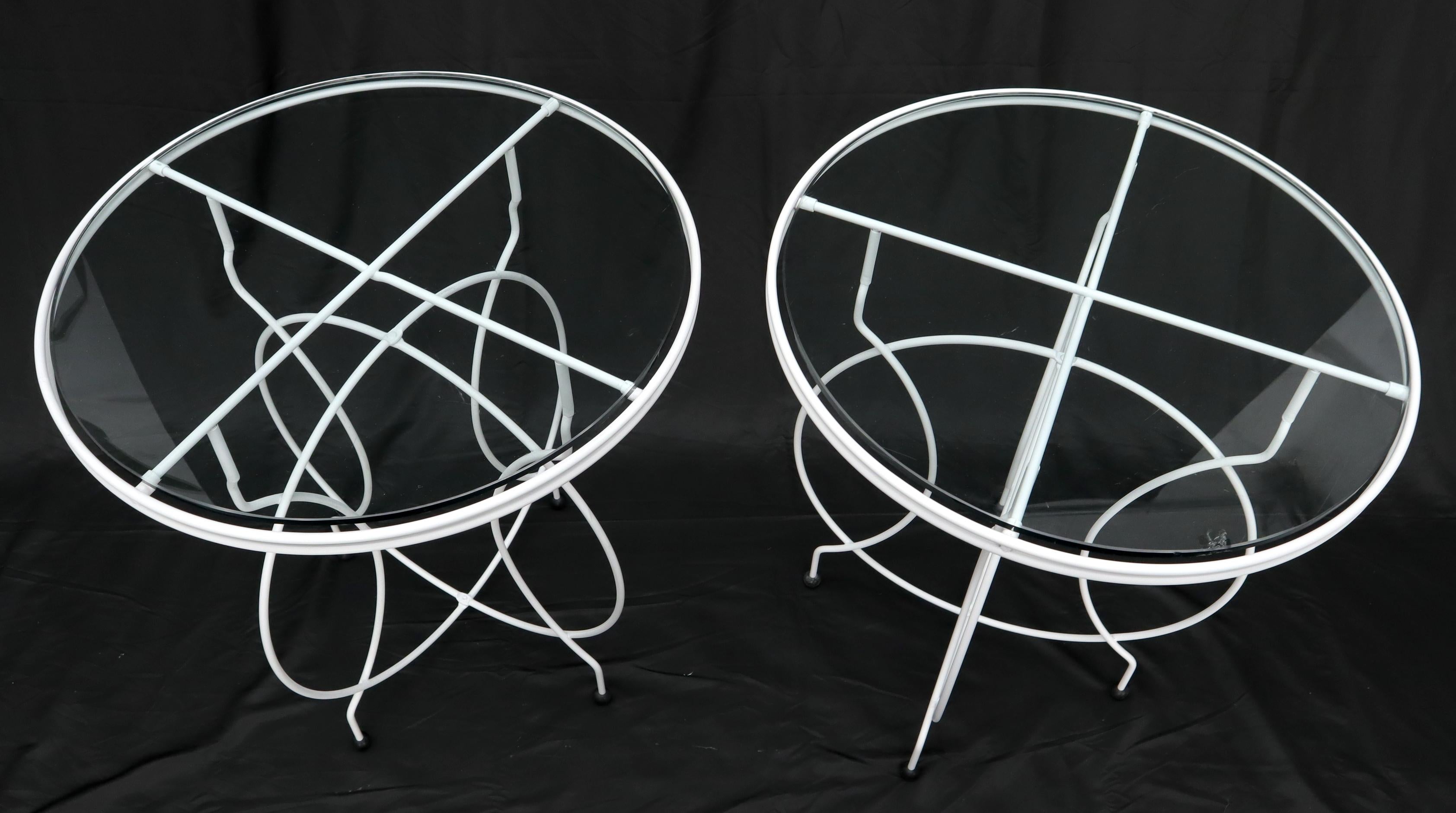 Pair of Mid-Century Modern round wire base folding cafe tables with glass tops on ball feet.