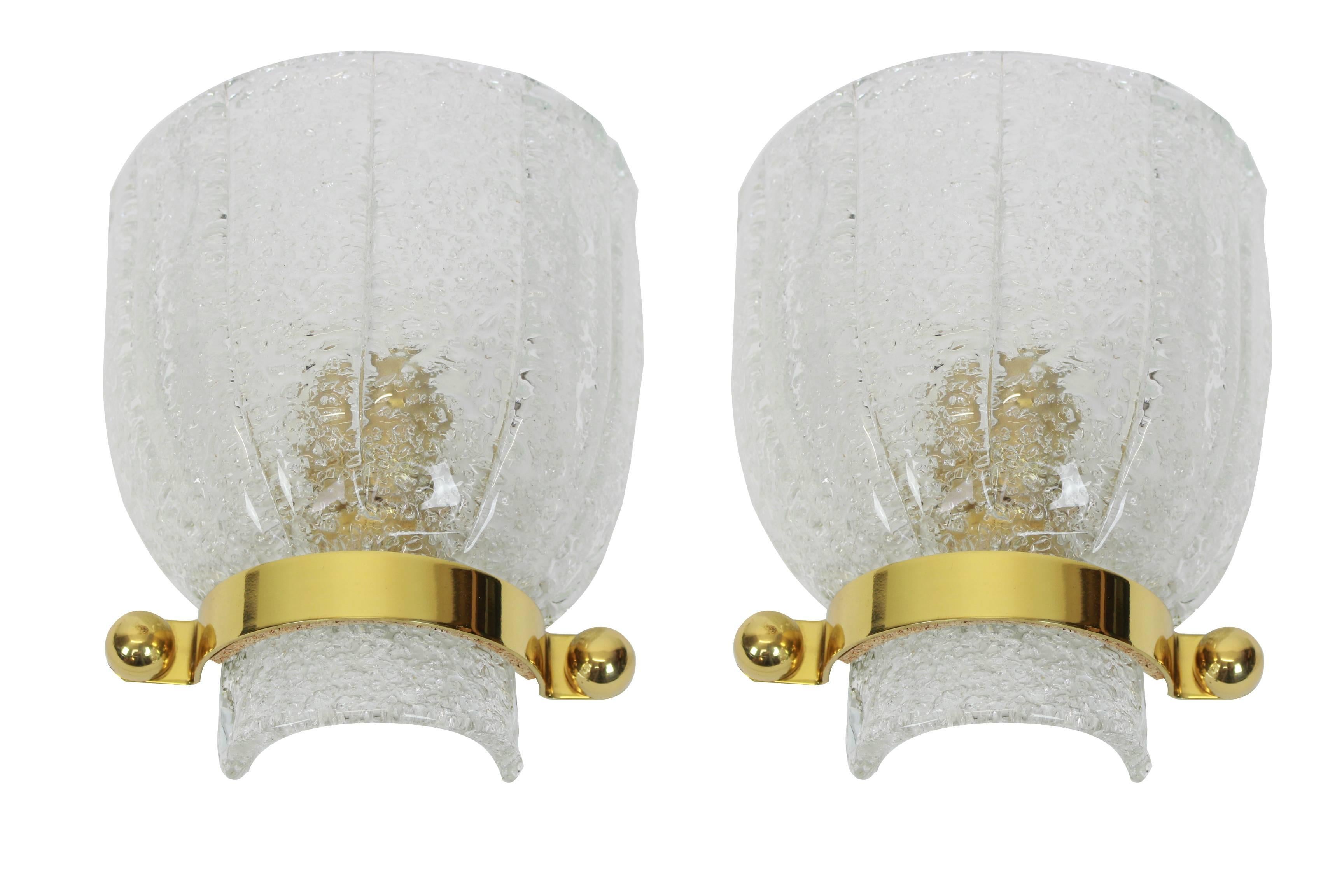 Wonderful pair of midcentury brass wall sconces with ice glass, made by Kalmar, Austria, manufactured, circa 1960-1969.

High quality and in very good condition. Cleaned, well-wired and ready to use. 

Each Sconce requires 1 x E14 Standard bulbs