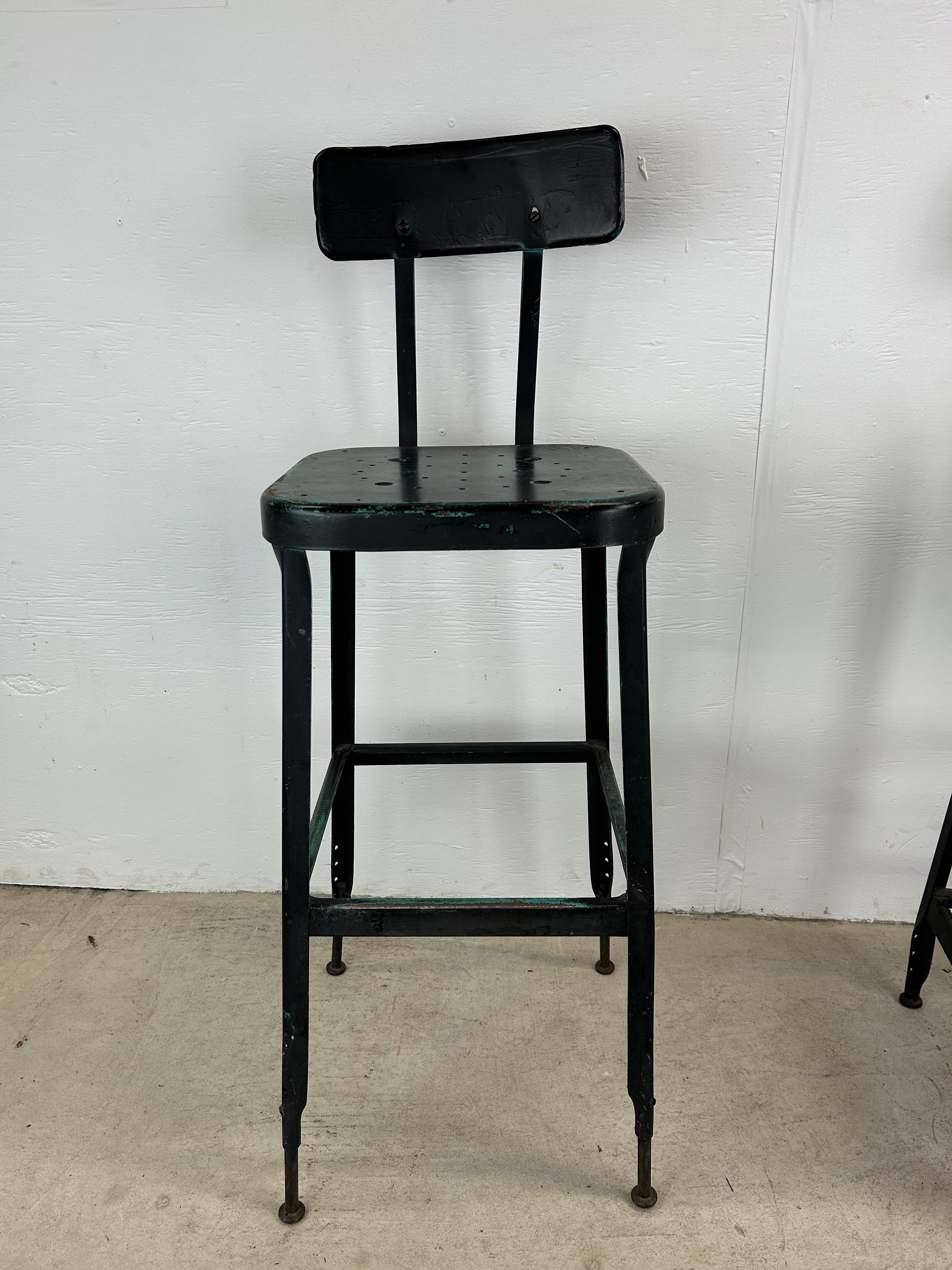 This pair of vintage industrial stools feature metal frame & seat back, unique patina caused by painting black over red & aqua colors, and tall tapered legs.

Complimentary kitchen cart / table available separately. 

Dimensions: 15.5w 15.5d 41.5h