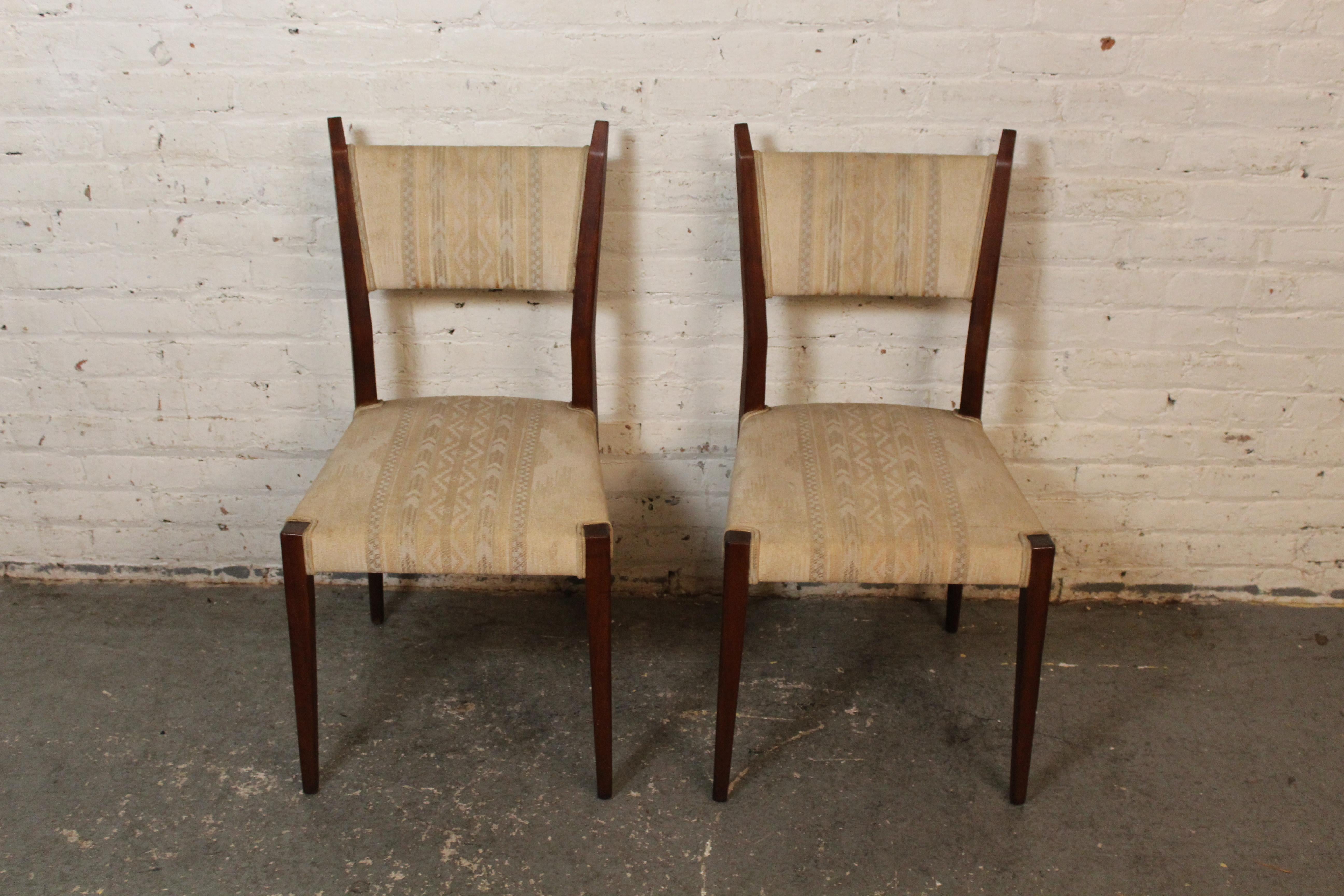 Diese auffälligen Stühle des legendären Designers Paul McCobb erinnern an die klassischen Linien des legendären amerikanischen Mid-Century Modern Designs. Das Paar aus Nussbaumholz wurde für die ikonische Collection'S Irwin
