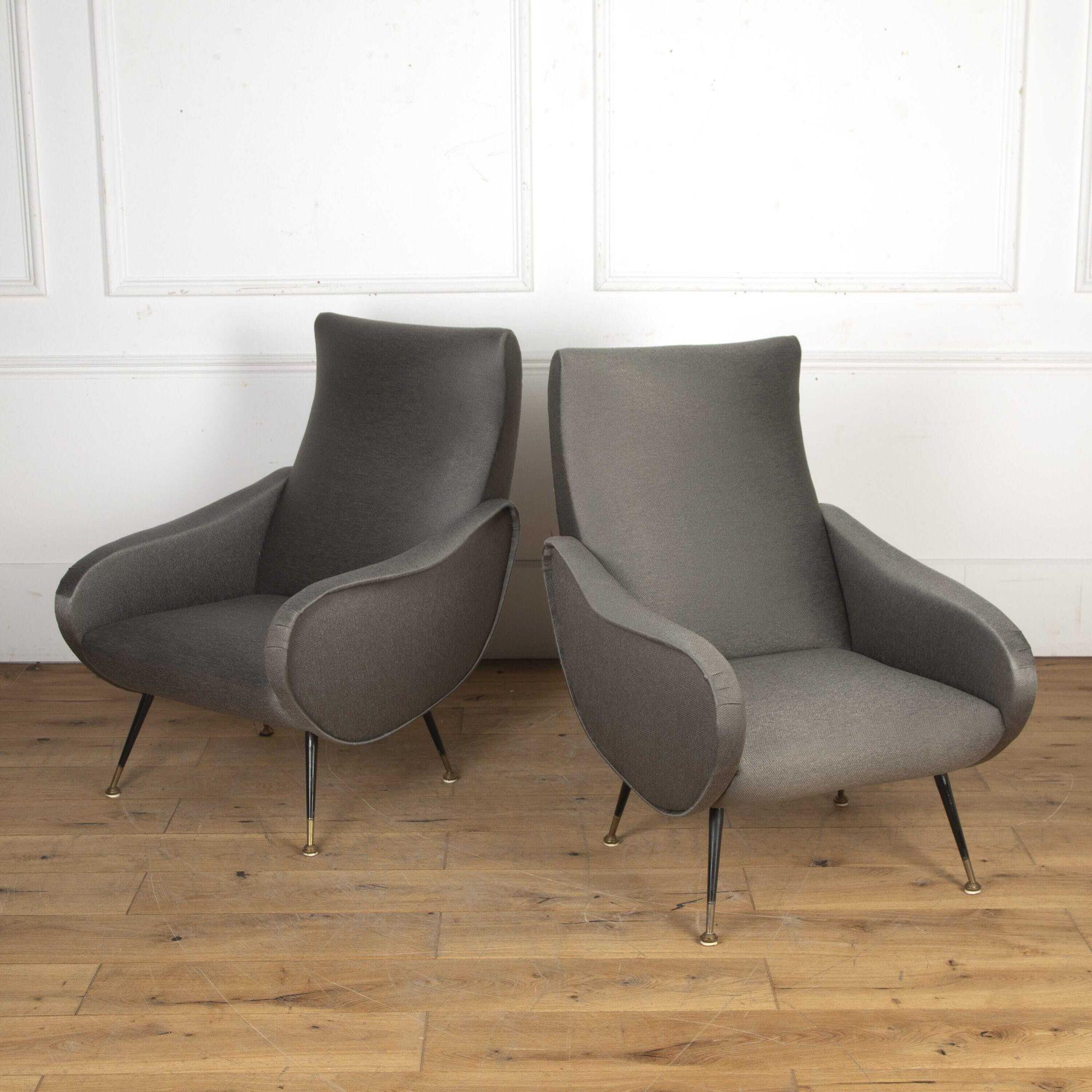 Pair of Italian midcentury armchairs in the style of Marco Zanuso.
This pair of chairs are in near immaculate condition, terminating on ebonized and brass feet and upholstered in a grey woven fabric.