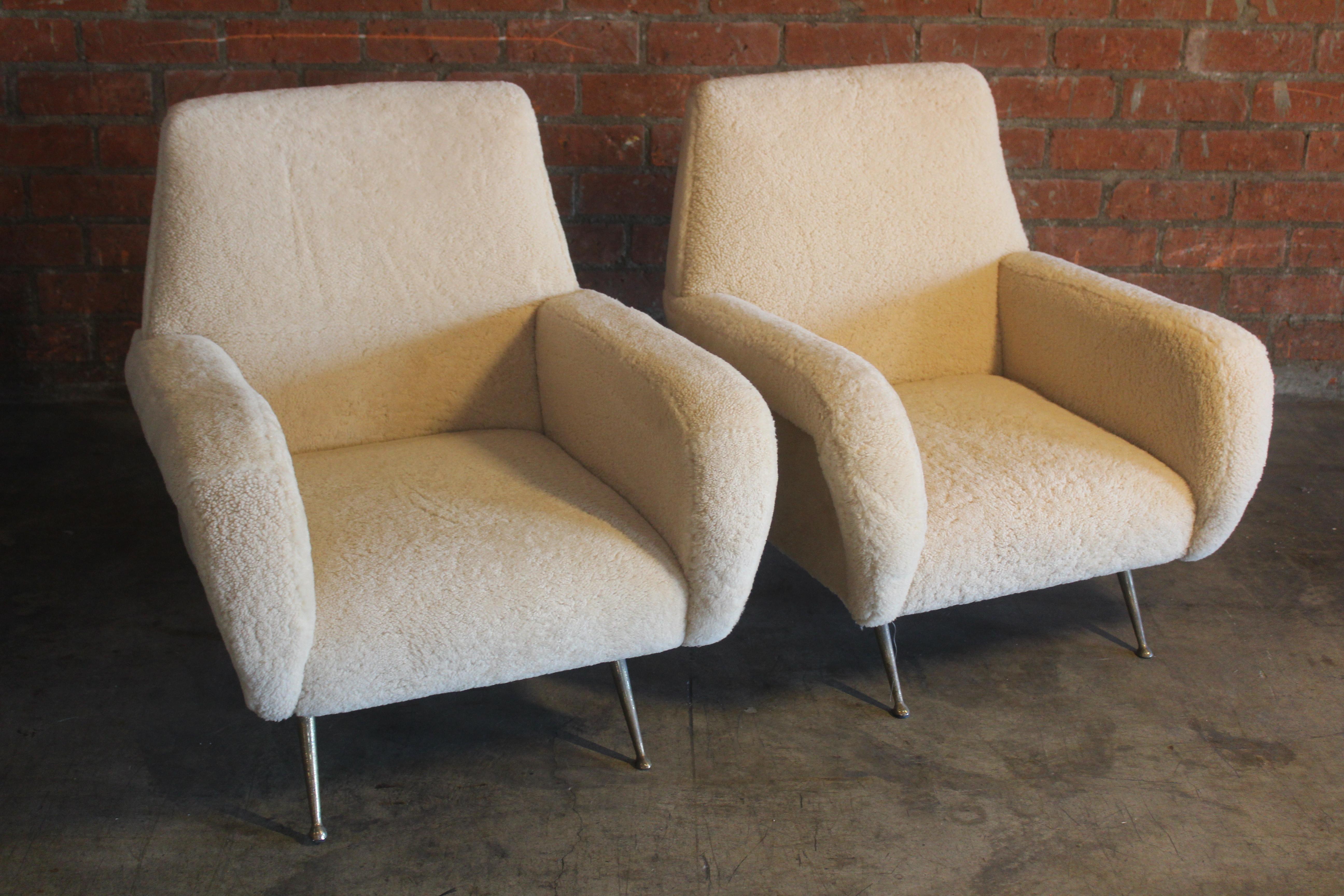 Pair of mid-century Italian armchairs with new sheepskin upholstery. They sit on brass legs. In overall excellent condition. The brass legs show patina. Sold as a pair. Armheight is 22