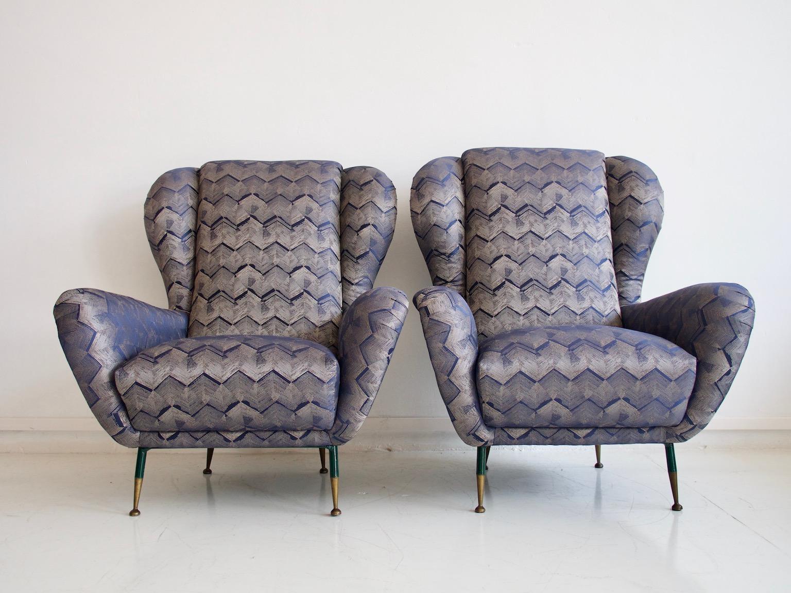 Beautiful pair of Italian 1950s armchairs reupholstered with dark blue and beige patterned slightly shiny fabric. Slim brass legs with dark green patina on the top part.