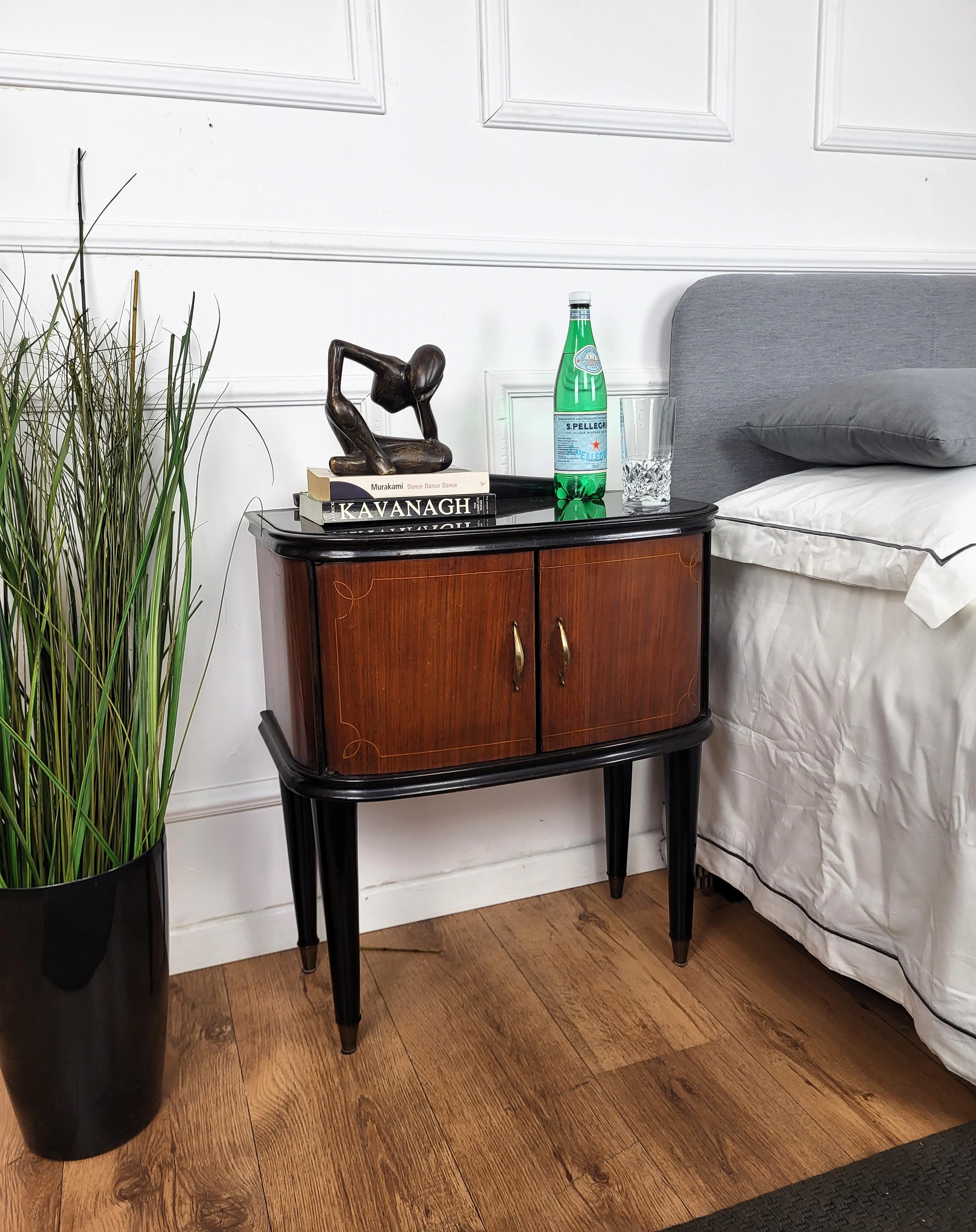 Very elegant and refined Italian 1950s Mid-Century Modern, neoclassical and empire style, in typical Art Deco design, pair of bedside tables with wood double front door, black glass top and wood veneer burl decors on the sides and doors, and brass