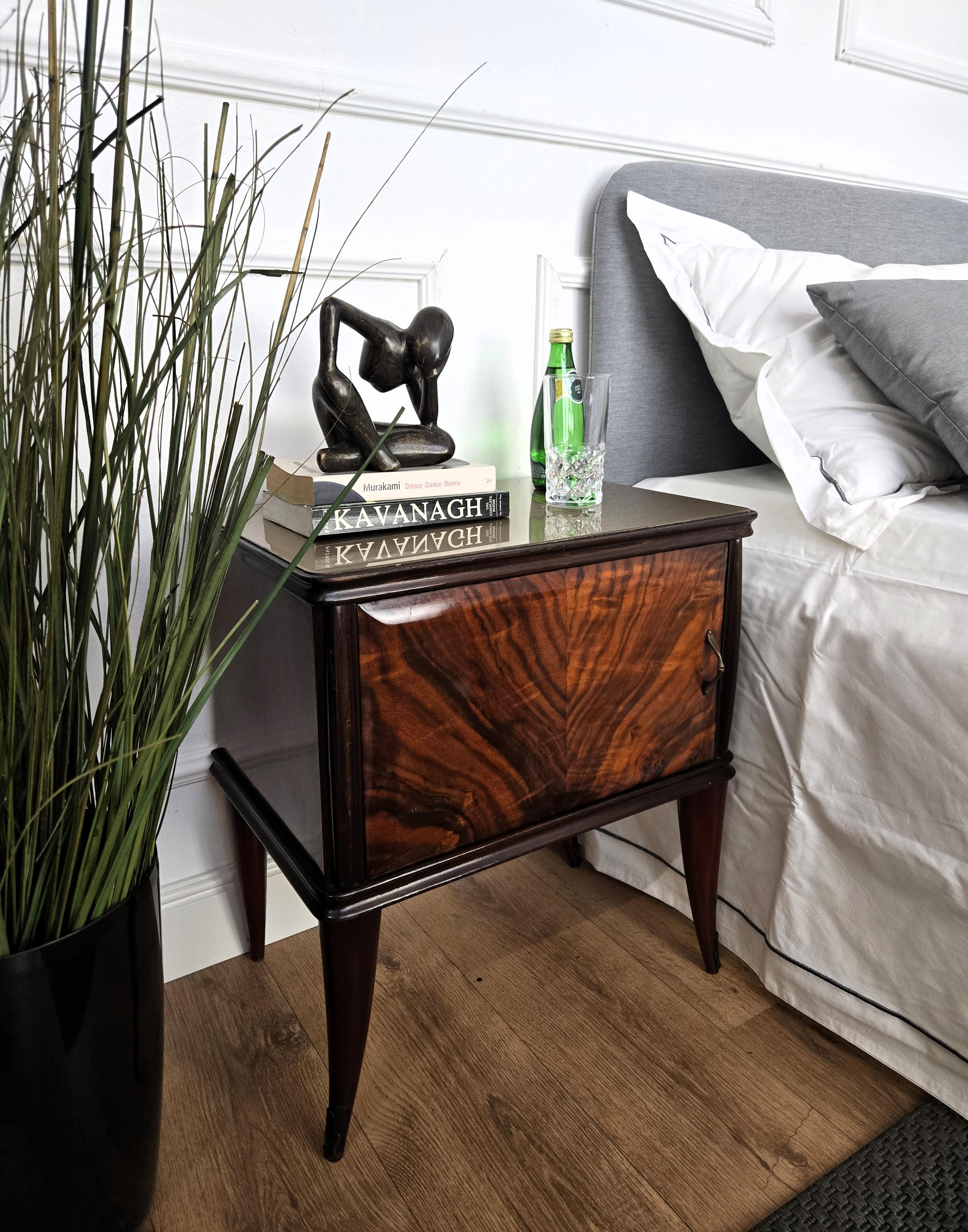 Very elegant and refined Italian 1950s Mid-Century Modern pair of bedside tables with front door, grey glass top and wood veneer decors on the sides and doors, and brass details such as the 2 handles and the 4 foot ends. 

Those pieces make a great