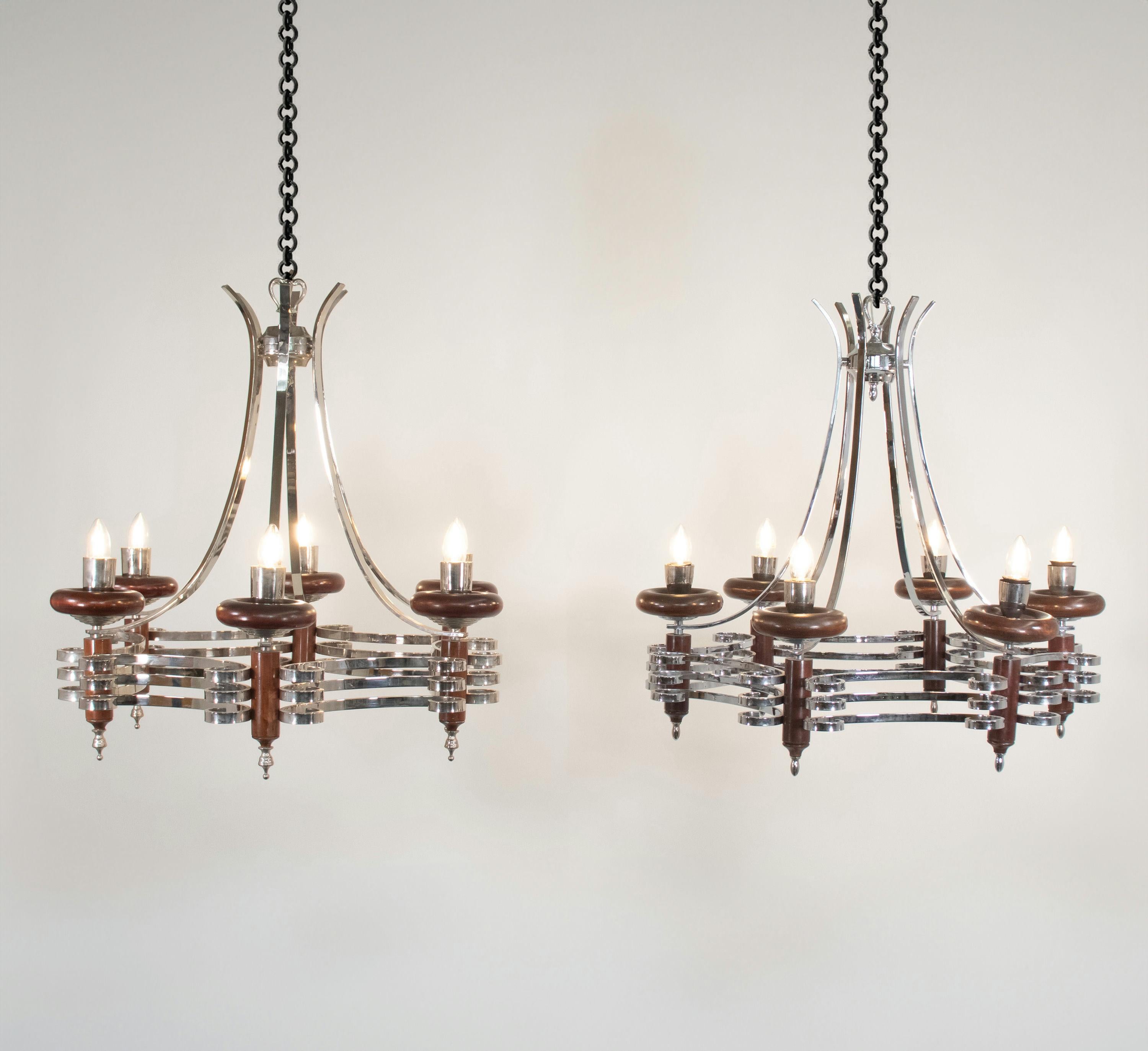Eleganza per la tua casa con questa coppia di lampadari in legno e cromo italiani del Medioevo. La giustapposizione di mogano massiccio e cromo crea una sinfonia visiva suggestiva e armoniosa. I raggi cromati, che collegano in modo elegante la parte