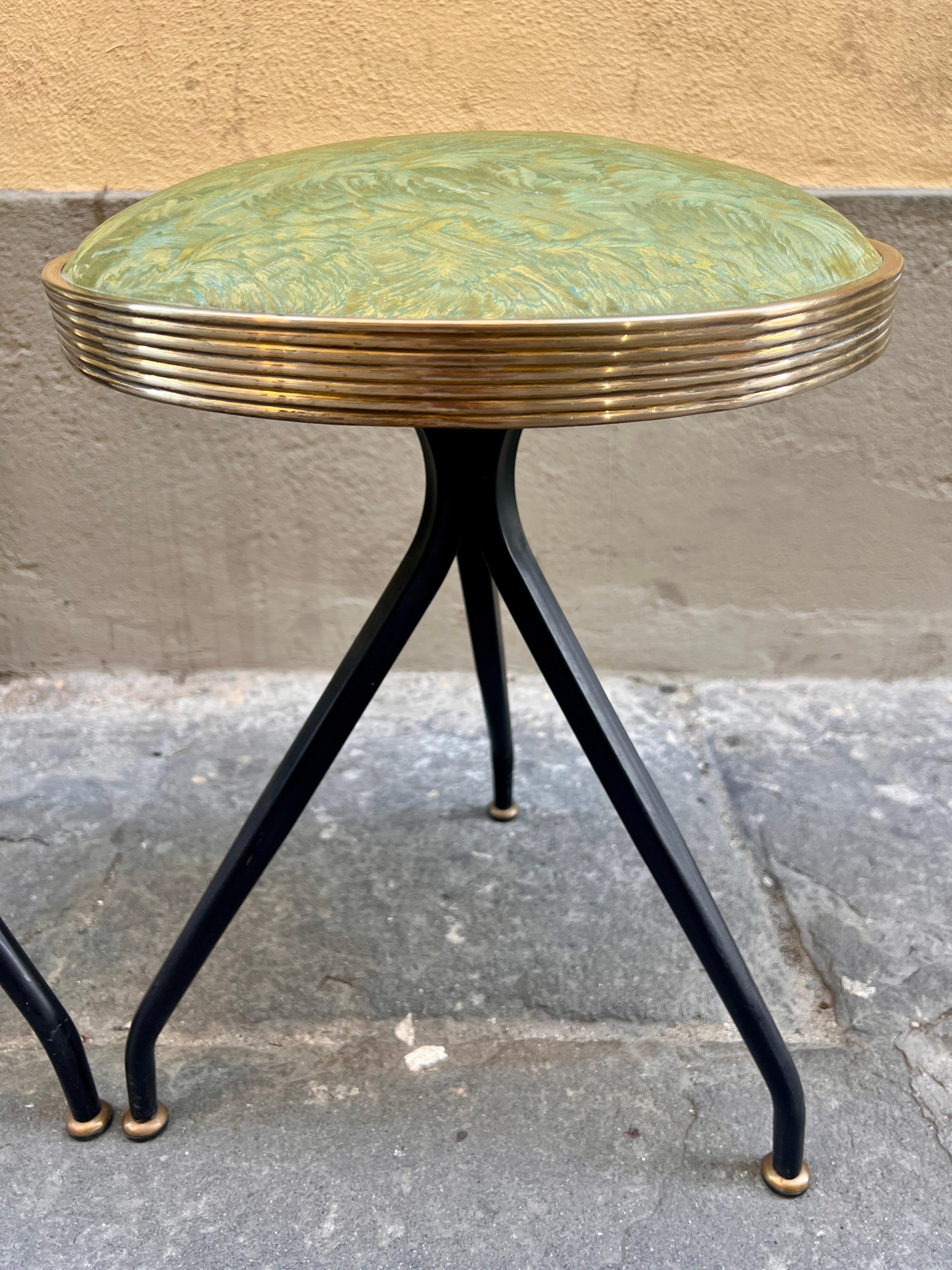 Paire de tabourets ronds en éco-cuir vert de style italien du milieu du siècle.
Le tabouret a trois pieds en métal et en laiton. La sellerie est d'origine, dans un magnifique tissu en éco-cuir irisé qui oscille entre le jaune et le vert.