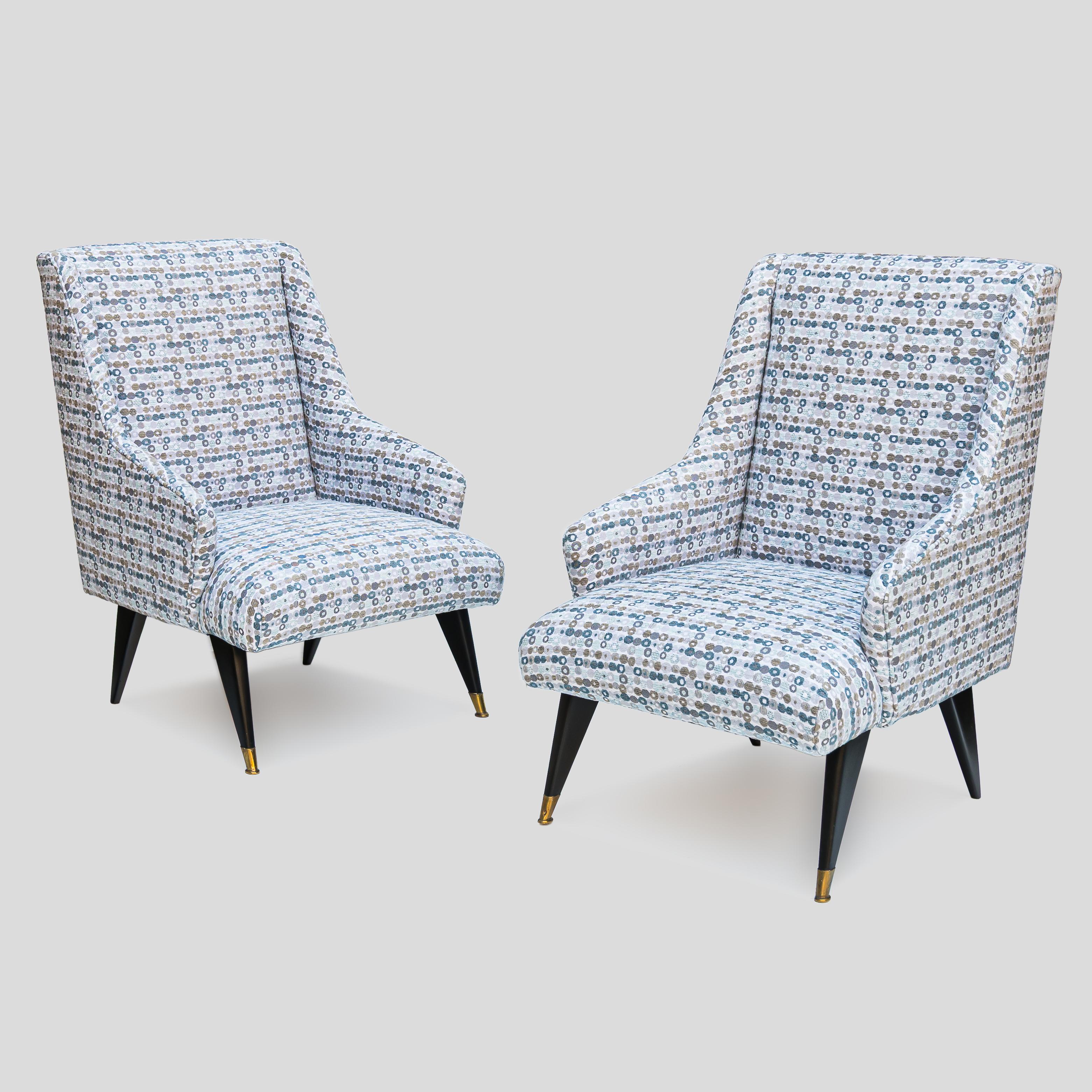 Pair of Mid century Italian design low seating armchairs with black feet. Tela en venta