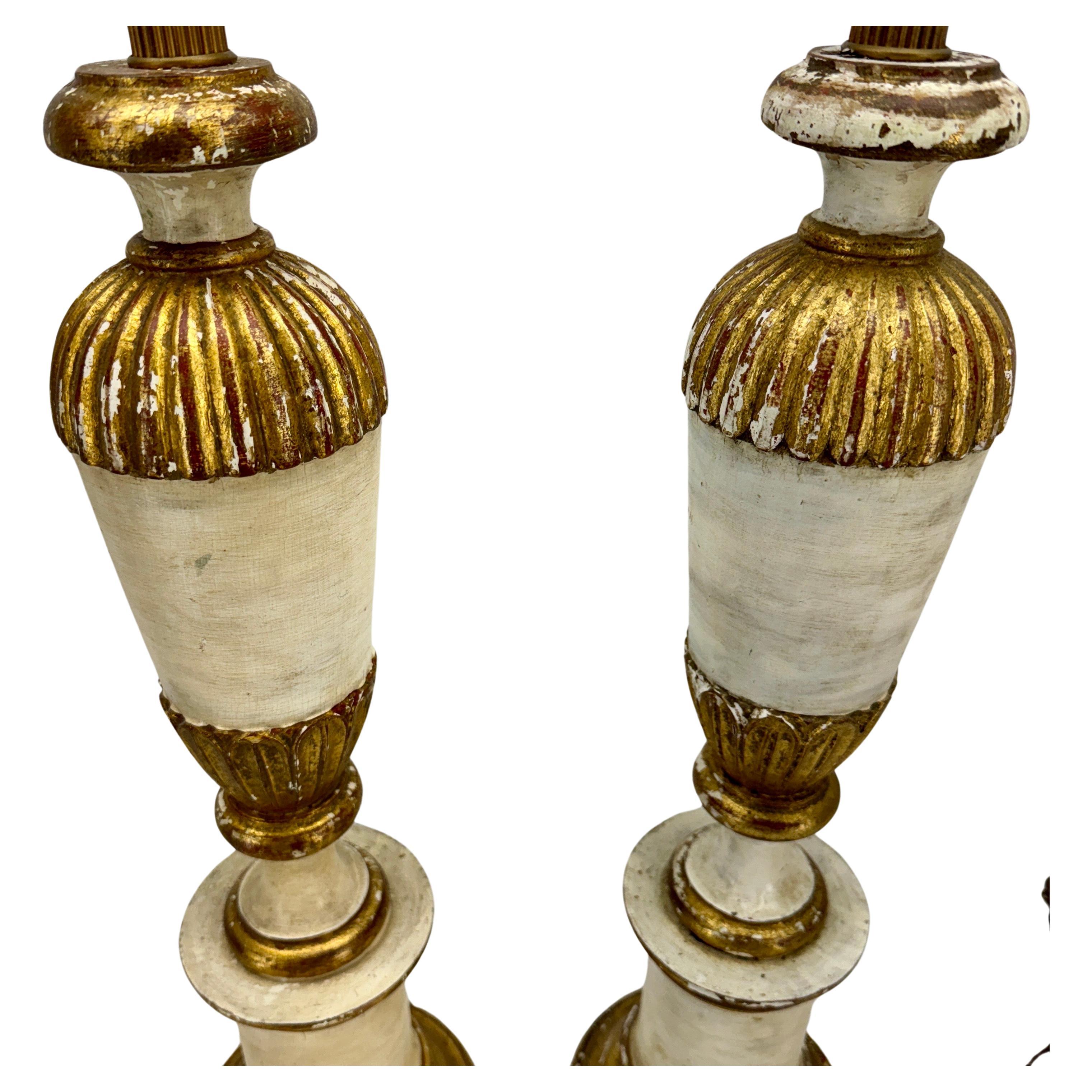 Mid-Century Italian Gilt Wood Painted Table Lamps, A Pair

Fantastic vintage pair of cream and gilded gold lamps with original patina. Crafted in Italy during the 1950’s, this pair would be elegant decorating a console, buffet or end tables in any