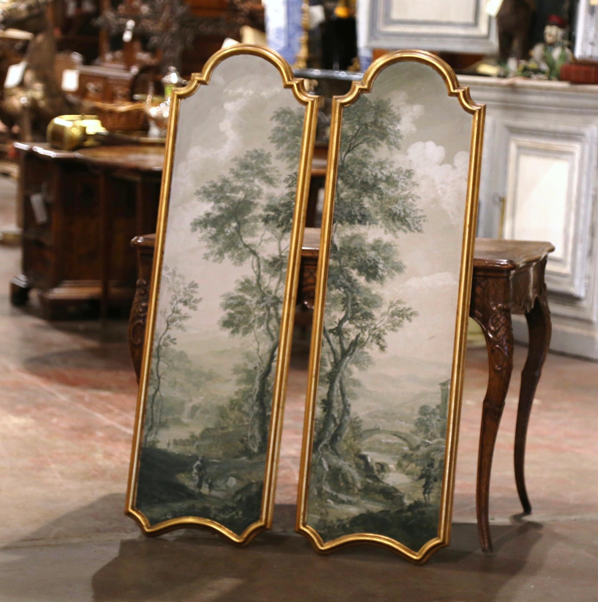 Decorate a study or entryway with this elegant pair of vintage panels. Hand painted in Italy circa 1960, the paintings are set in a carved gilt frame with arched top; each artwork depicts a nature scene of tall trees towering over a man fishing in a