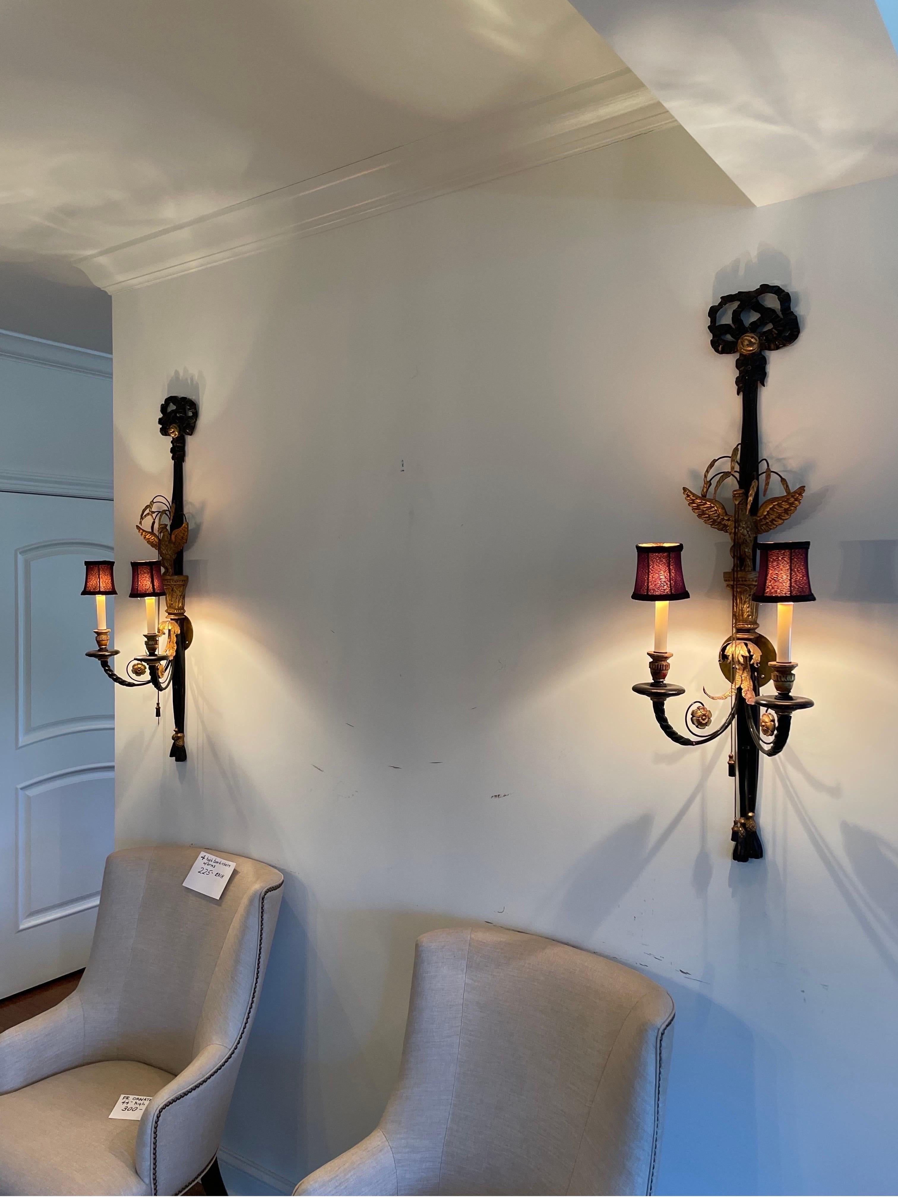 Spectacular pair of neoclassical wall sconces. Giltwood Ribbon design with tassel, adjustable chain, wonderful eagles and floral details.