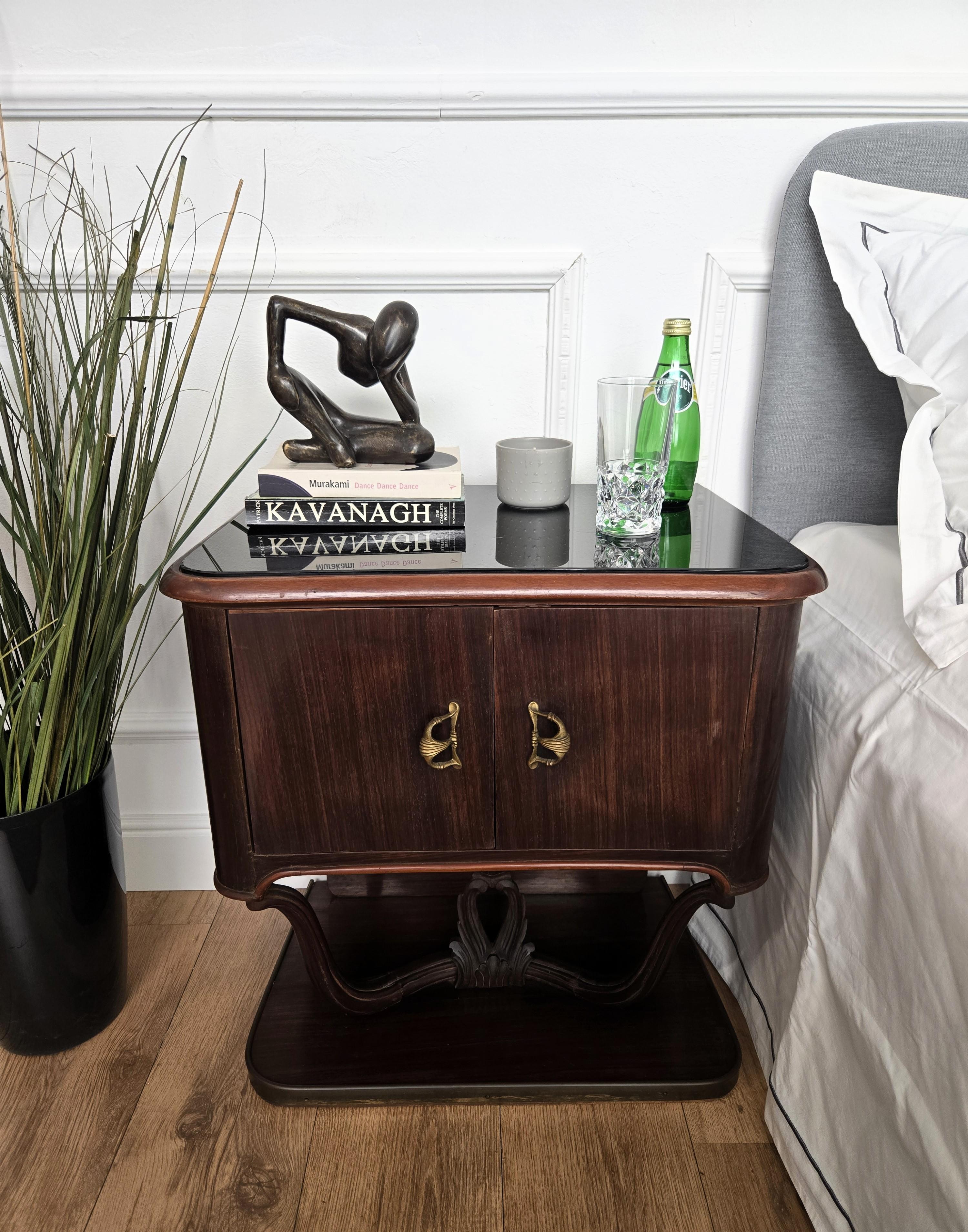 Very elegant and refined Italian 1950s Mid-Century Modern design, pair of bedside tables with double front door, black glass top and beautiful wood veneer burl decors on the sides and doors highlighted by the brass details such as the handles and