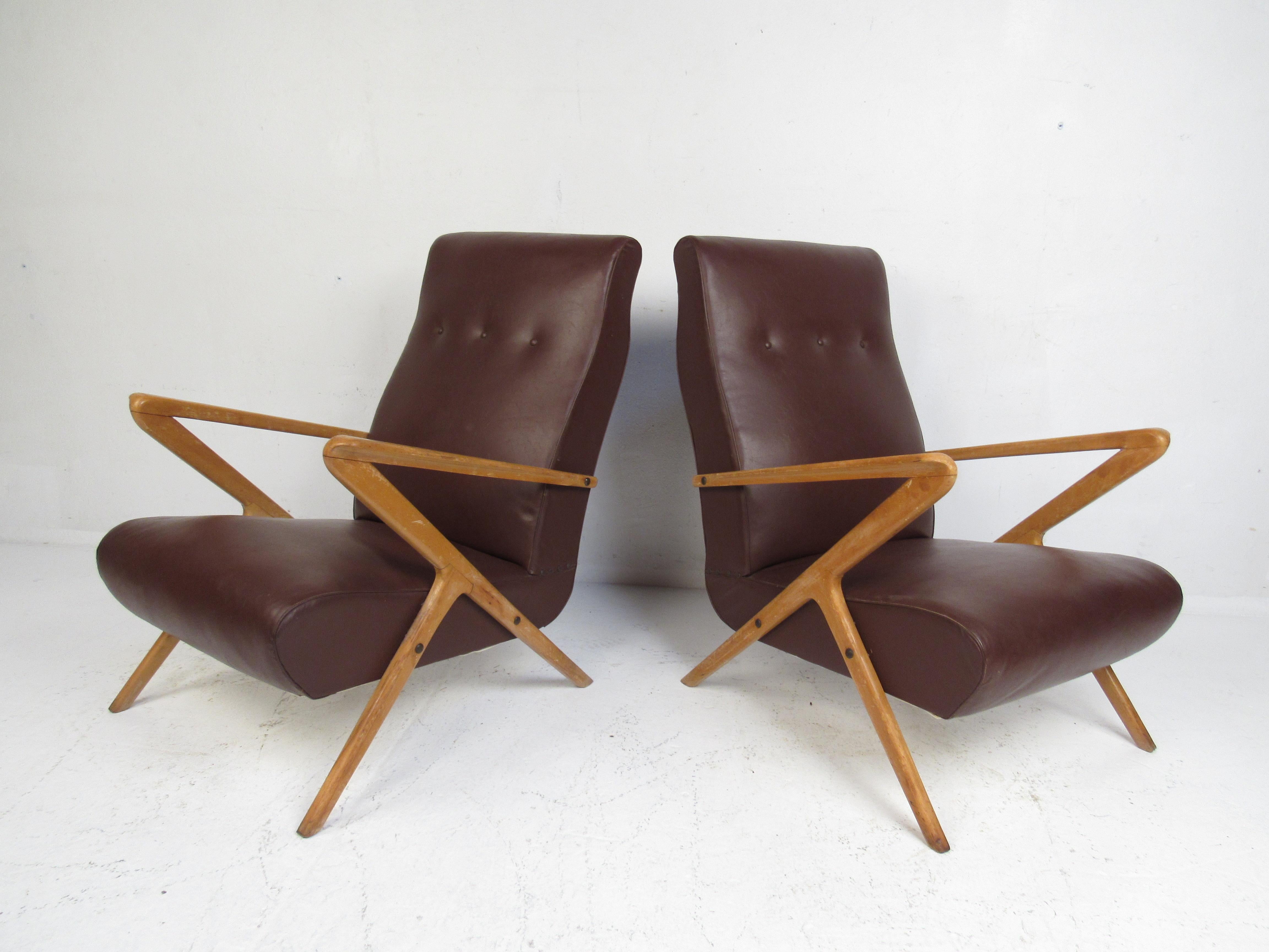A stunning pair of vintage Italian modern lounge chairs that feature a sculpted teak frame with 