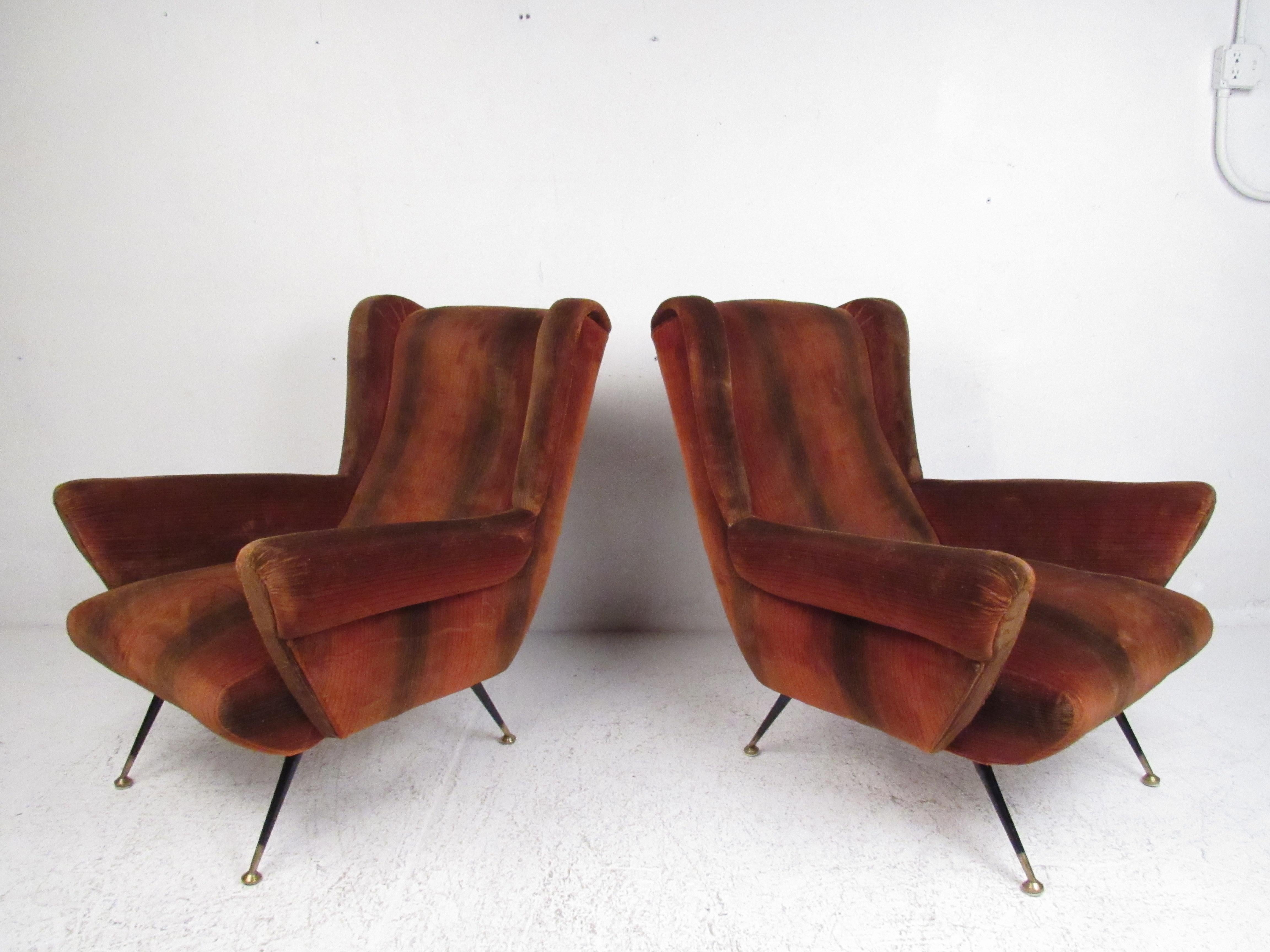 This beautiful pair of vintage modern Italian lounge chairs boast winged backrests and armrests ensuring maximum comfort. The splayed metal legs have brass feet showing quality craftsmanship. A sleek design that is sure to make a lasting impression