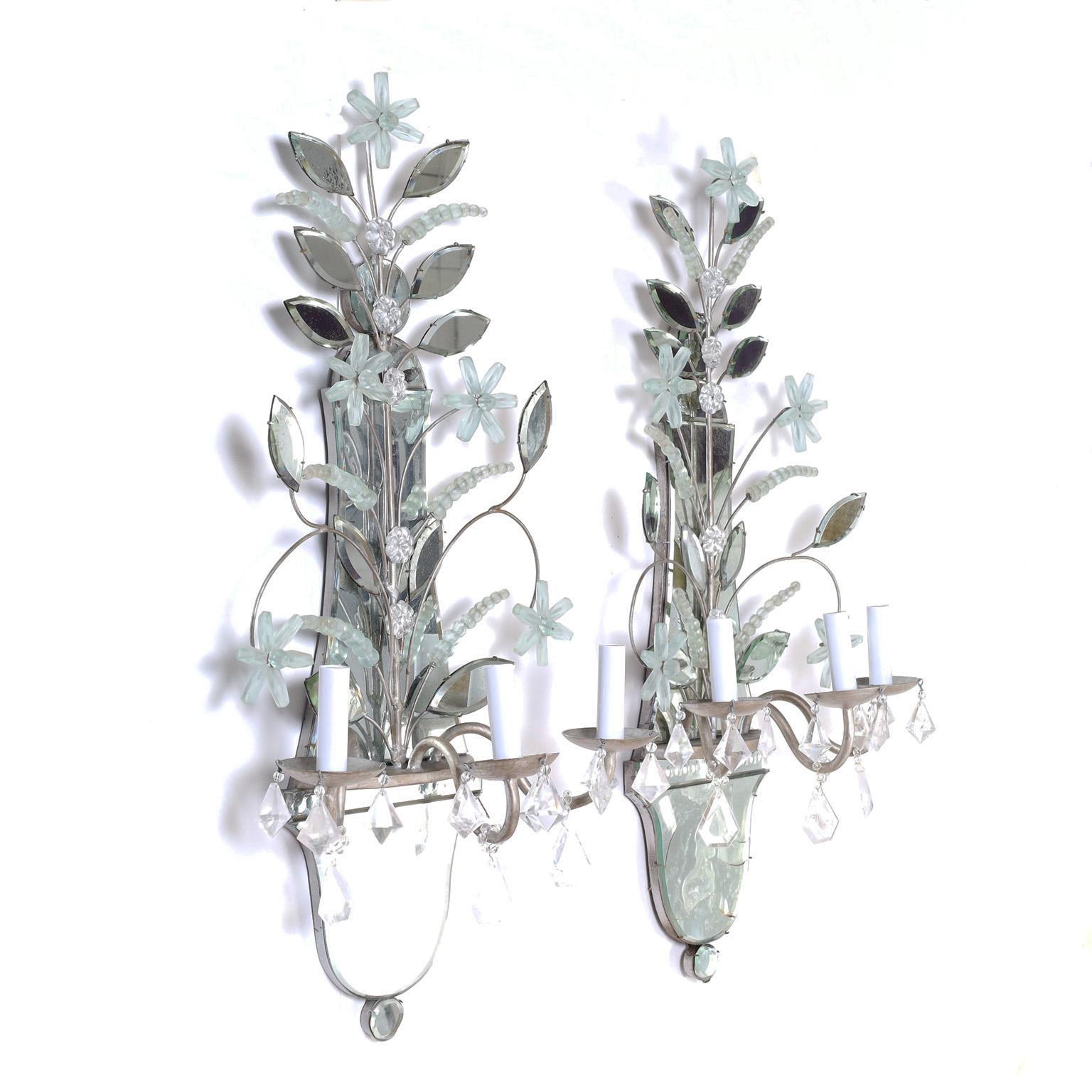 Dramatic pair of vintage Venetian style Italian wall sconces with Classic mirrored backplates featuring frosted glass flowers, beads and cut rock crystals hanging from the three metal arms.