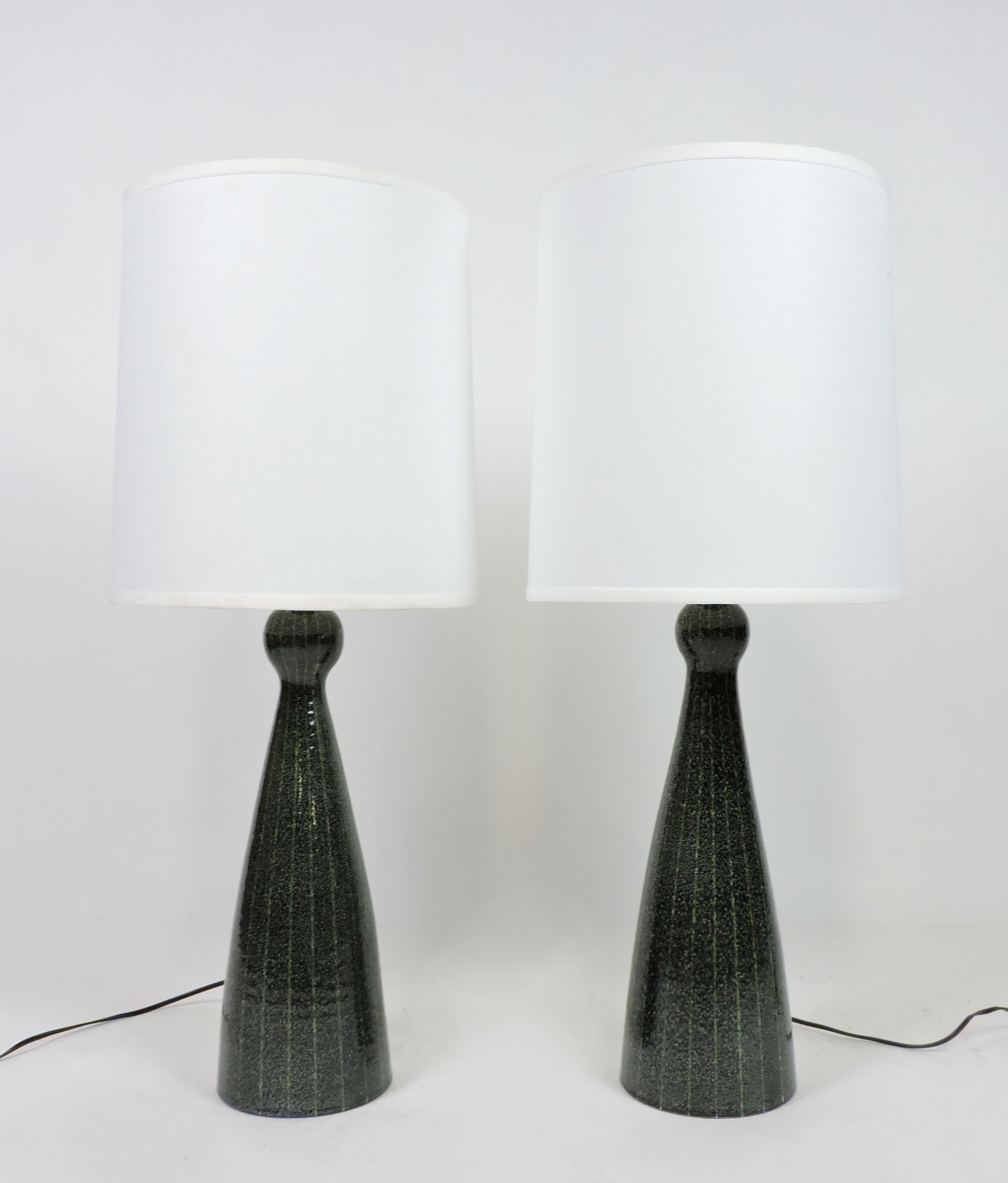 Handsome pair of large Italian ceramic table lamps made in Italy and possibly by Bitossi. These lamps have a beautiful dark green glaze and a curvy, bulbous shape. The bottoms are numbered and signed, Italy, B. 
The shades are not included.