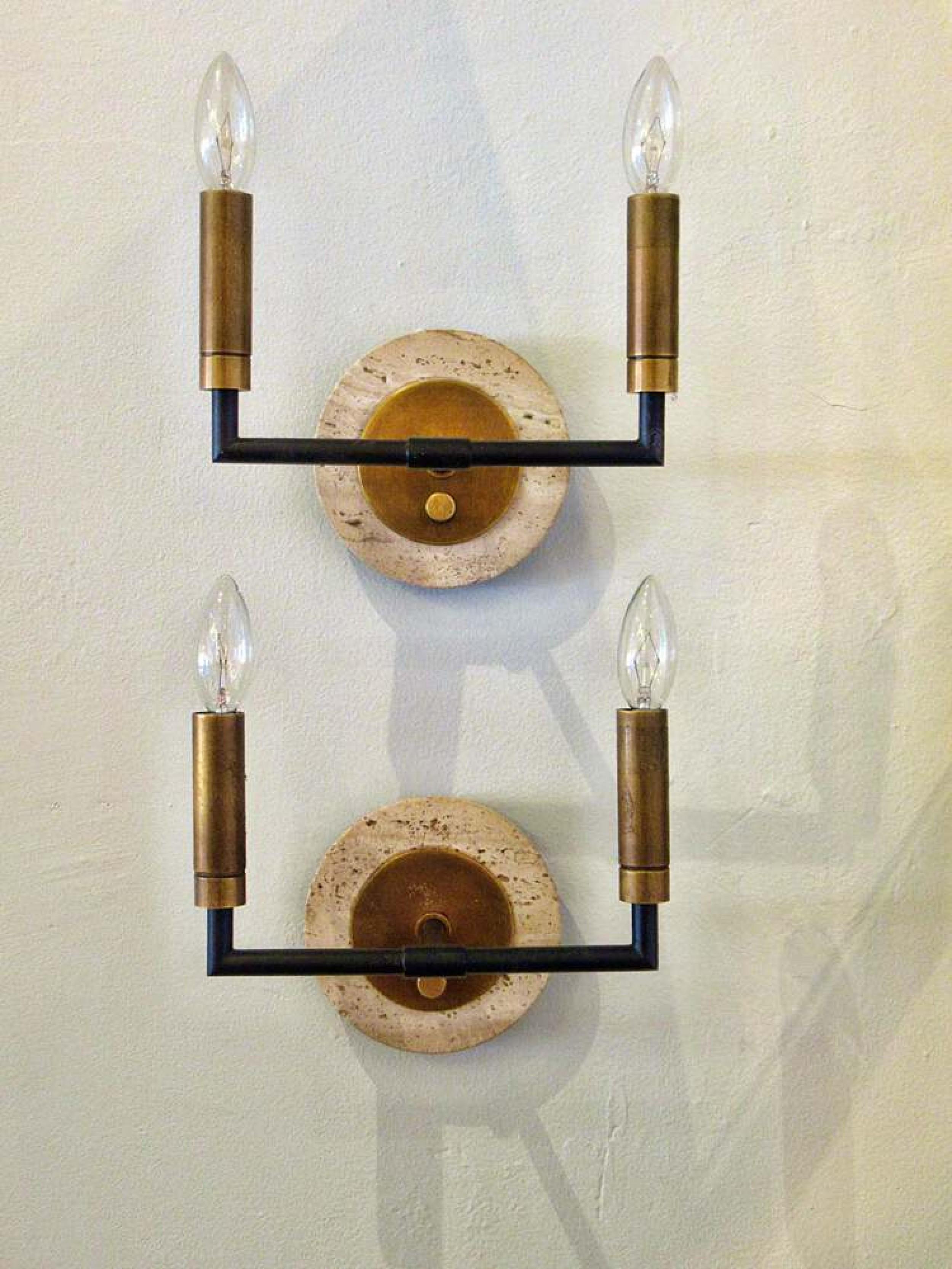 PAIR of midcentury Italian Modern (1950s) two-light wall sconces with a black metal cross bar connected to two burshed gilt metal lights, mounted on a travertine wall plate. (PRICED AS PAIR).