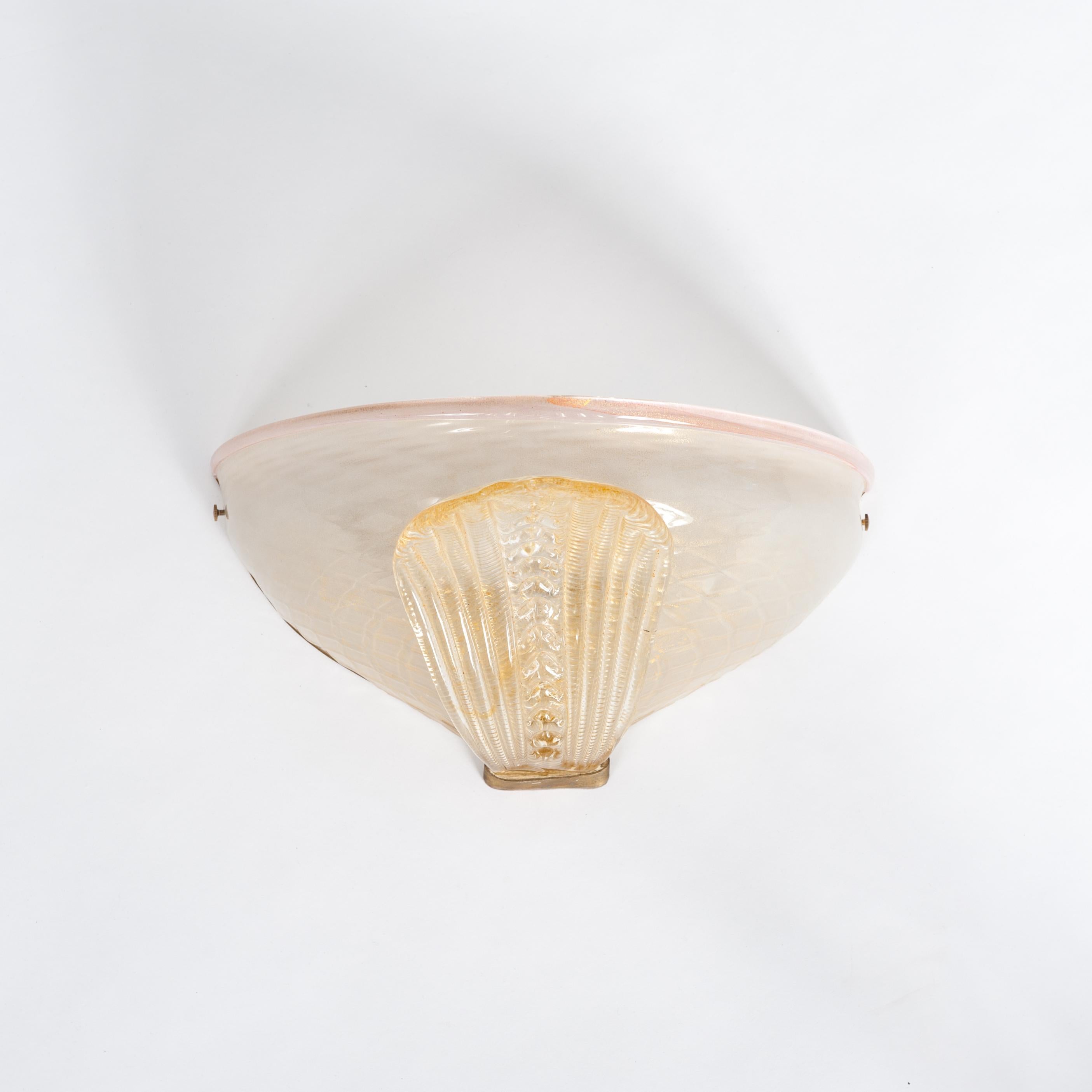 Pair of Murano glass wall lamps in transparent gold tone with rose-colored details. 
Half-shell shape with a stylized leaf as front decoration. 2-lit electrified.
Due to the leaf in the front, the objects also have a sculptural