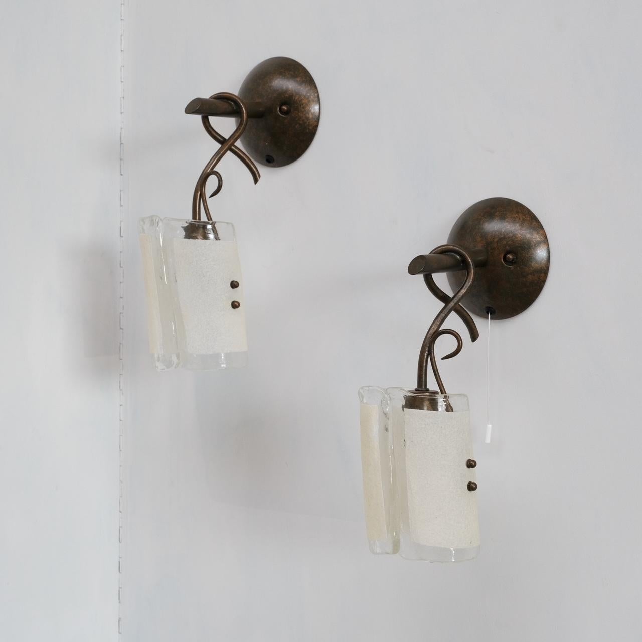 A pair of mid-20th century brass and glass wall lights. 

Italy, c1960s. 

Thick folded murano glass. 

Price for the pair. 

Since re-wired and PAT Tested. 

Location: Belgium Gallery. 

Dimensions: 15 W x 35 H x 16 D in cm.