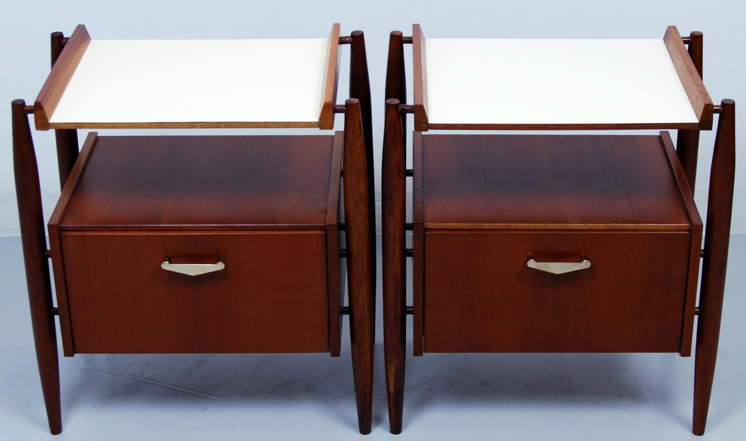 Stylish Italian pair of teak and formica midcentury bedside tables with slim tapered legs on offsets and with brass pulls. Manufactured by Dal Vera Mobili.
 