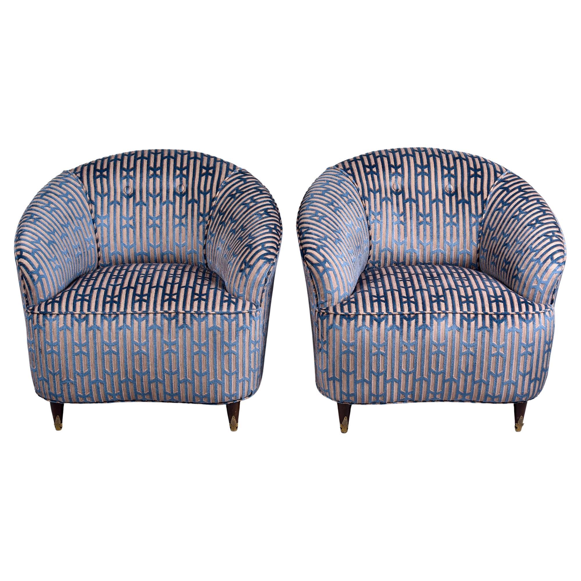 Circa late 1940s / early 1950s pair of Italian tub chairs with curvy lines and new upholstery. New, commercial grade fabric is taupe with blue velvet pattern. Tapered wood feet with brass trim. Unknown maker. Sold and priced as a pair. 

Arm