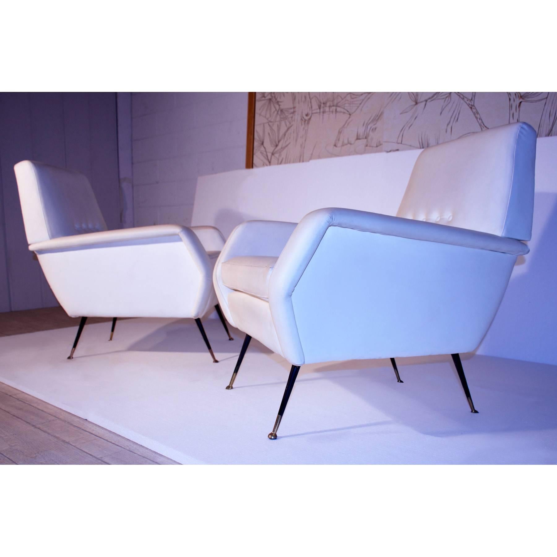 Very stylish and extremely comfortable pair of Italian wingback armchairs or club chairs sitting on polished brass legs, designed in the style of Gio Ponti and original of the 1950s.
Their seats are upholstered in white leatherette in excellent