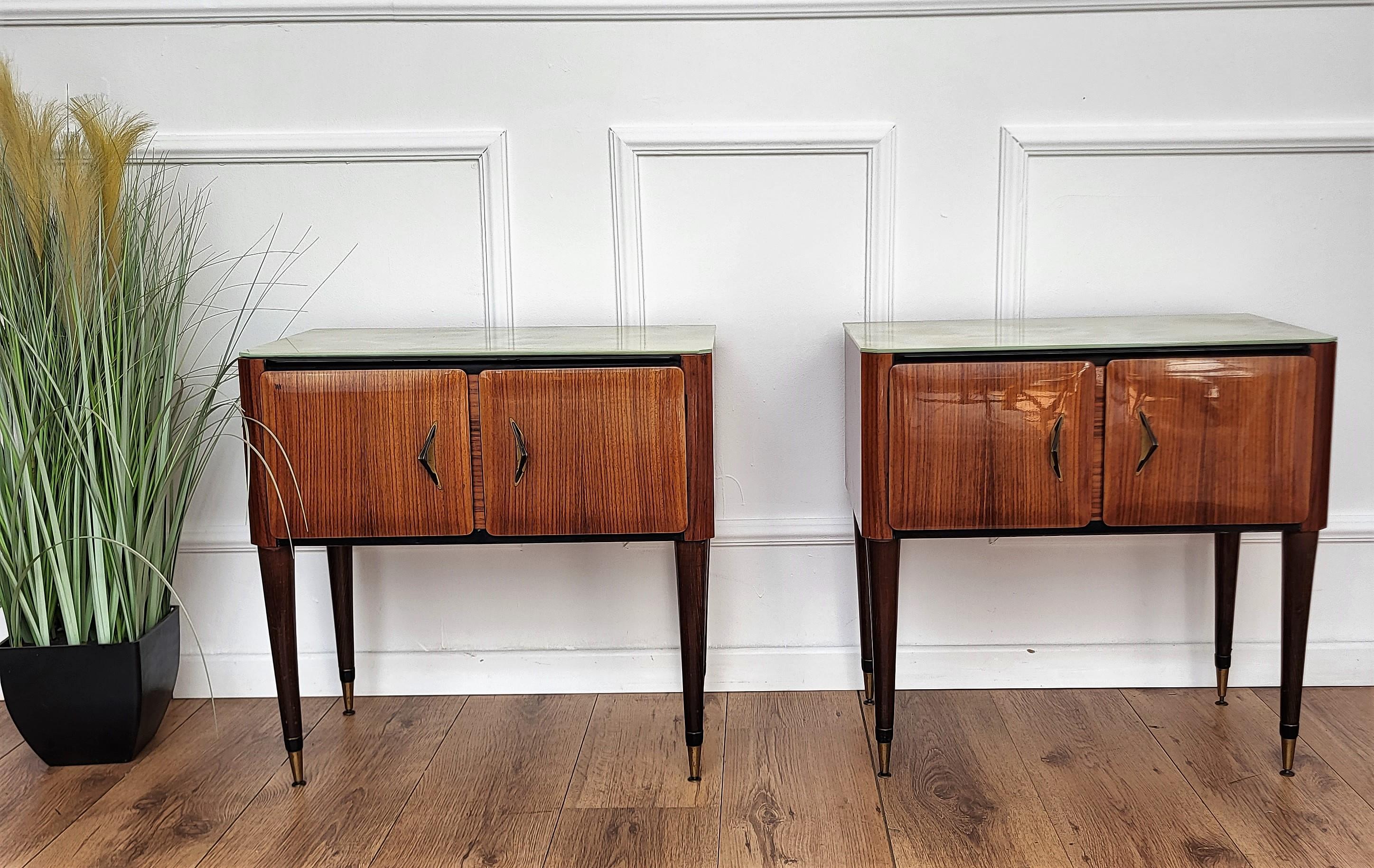Very elegant and refined Italian 1950s Mid-Century Modern, neoclassical, in typical Art Deco design, pair of bedside tables with wood double front door, white marble lacquered glass top and brass details such as the 2 handles and the 4 foot ends.