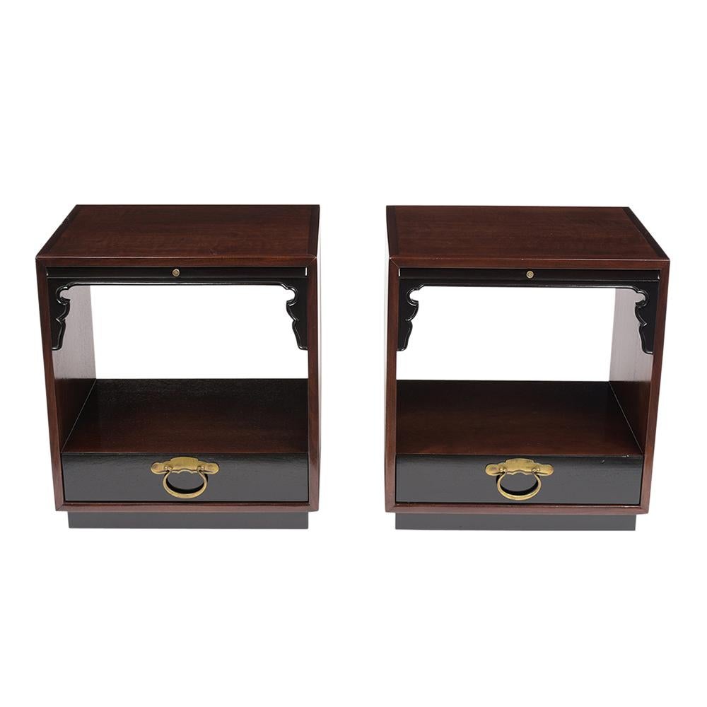This pair of midcentury style nightstands by Widdicomb has been restored and stained a rich mahogany and black color combination with a lacquered finish. Each nightstand has a pullout leaf with a brass knob, carved molding details above the open