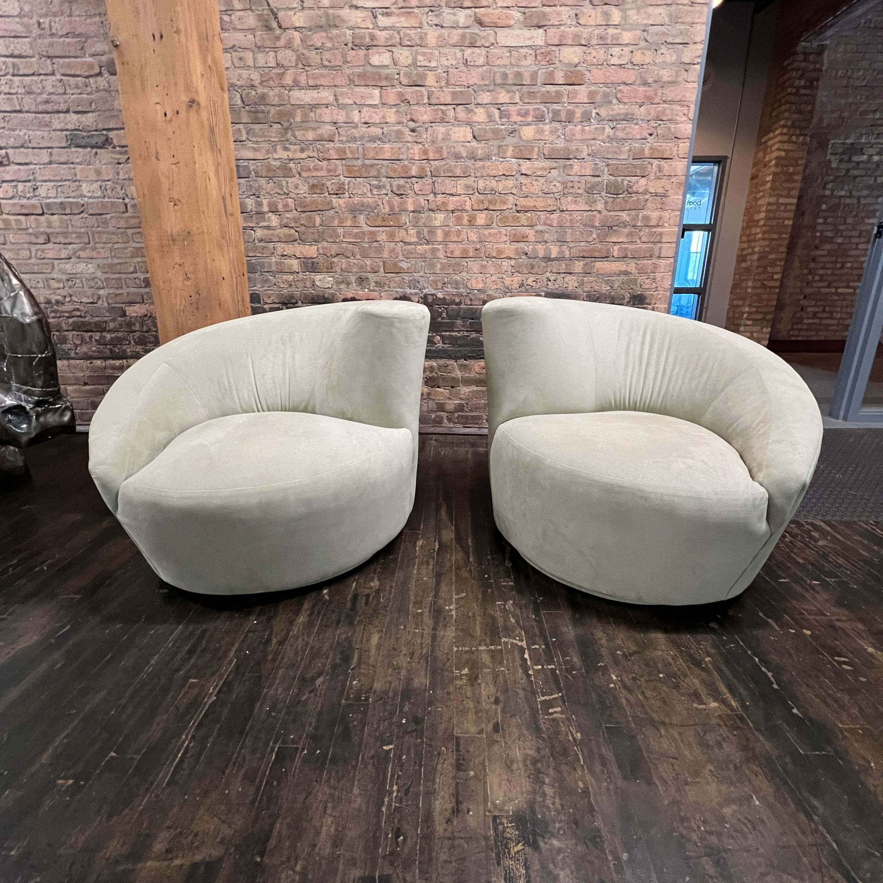 A lovely pair of mid-century modern nautilus asymmetrical swivel lounge chairs in a light green ultrasuede.  This pair came to use already reupholstered so labels are not intact.  The previous owner said they were purchased at the Merchandise Mart