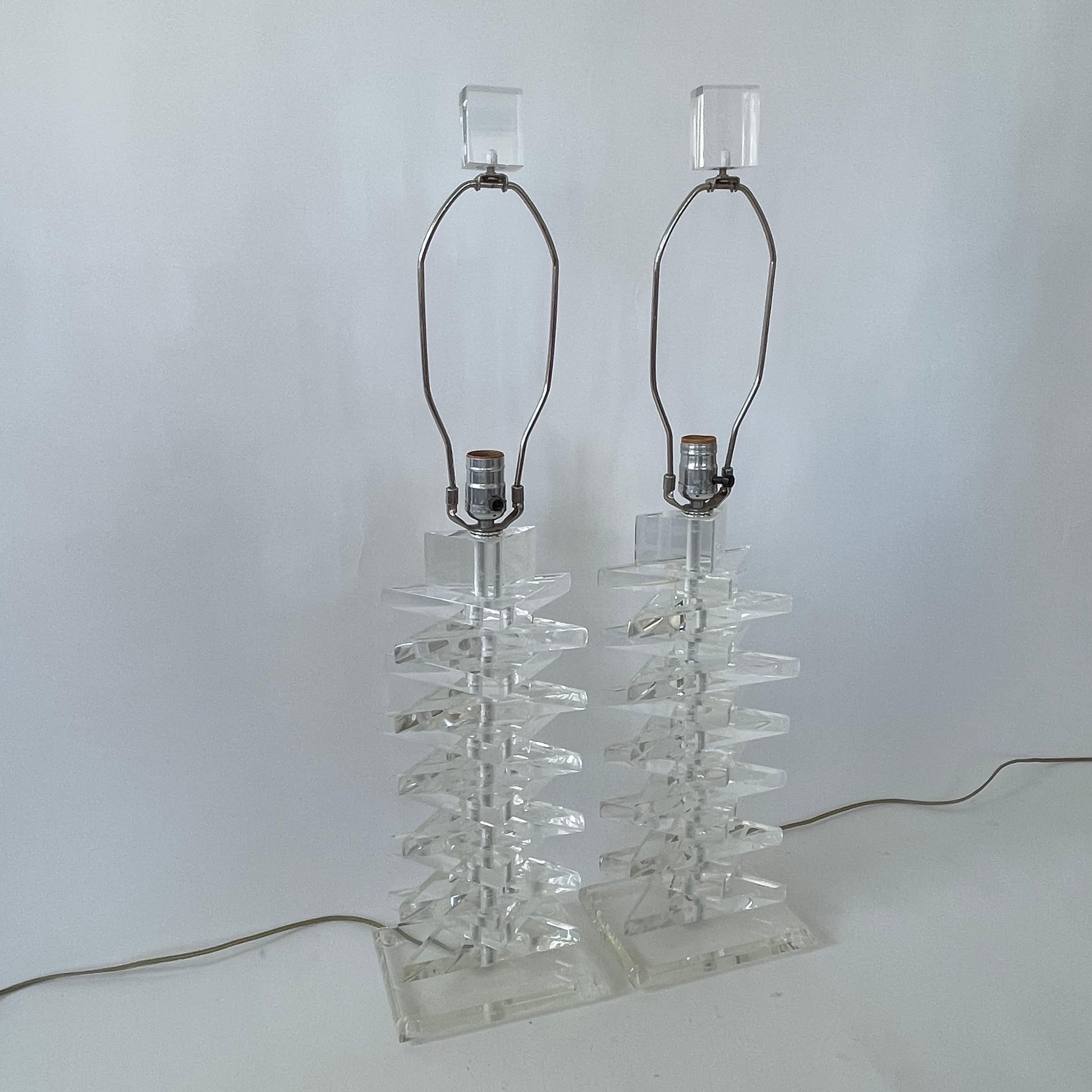 Eccezionale coppia di lampade da tavolo in lucite impilate della metà del secolo scorso, realizzate con triangoli in lucite lucida impilati in direzioni alternate con una base e finali in lucite, nello stile di Karl Springer, USA, anni '70