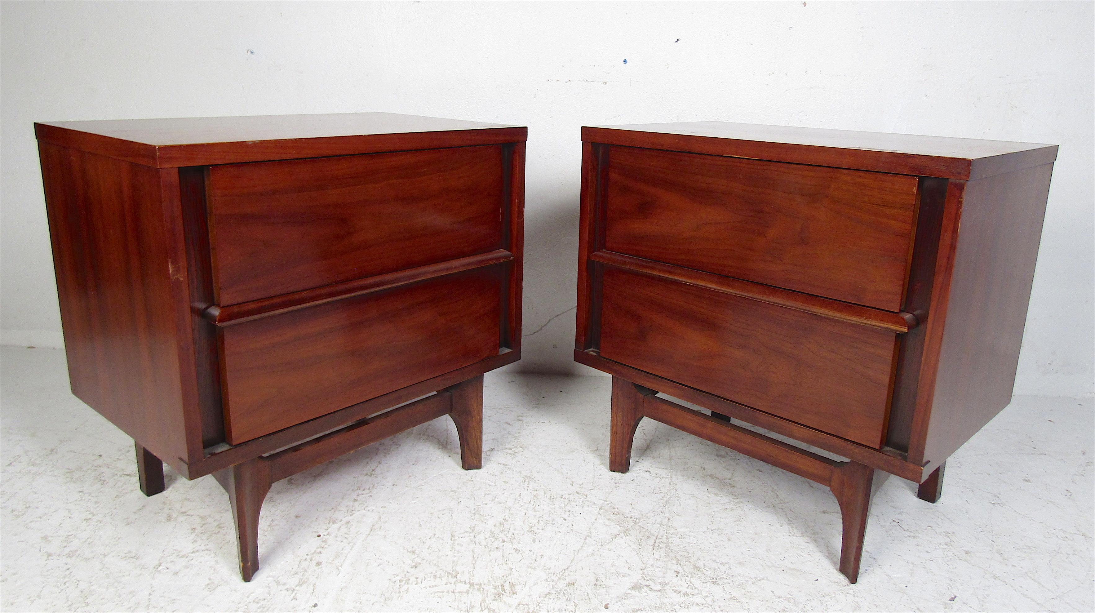 Beautiful pair of Mid-Century Modern Kent Coffey Predicta nightstands. Well-made case pieces with a vintage walnut finish, sculpted legs, and two hefty drawers ensuring ample storage space. This sleek pair of side tables make the perfect addition to