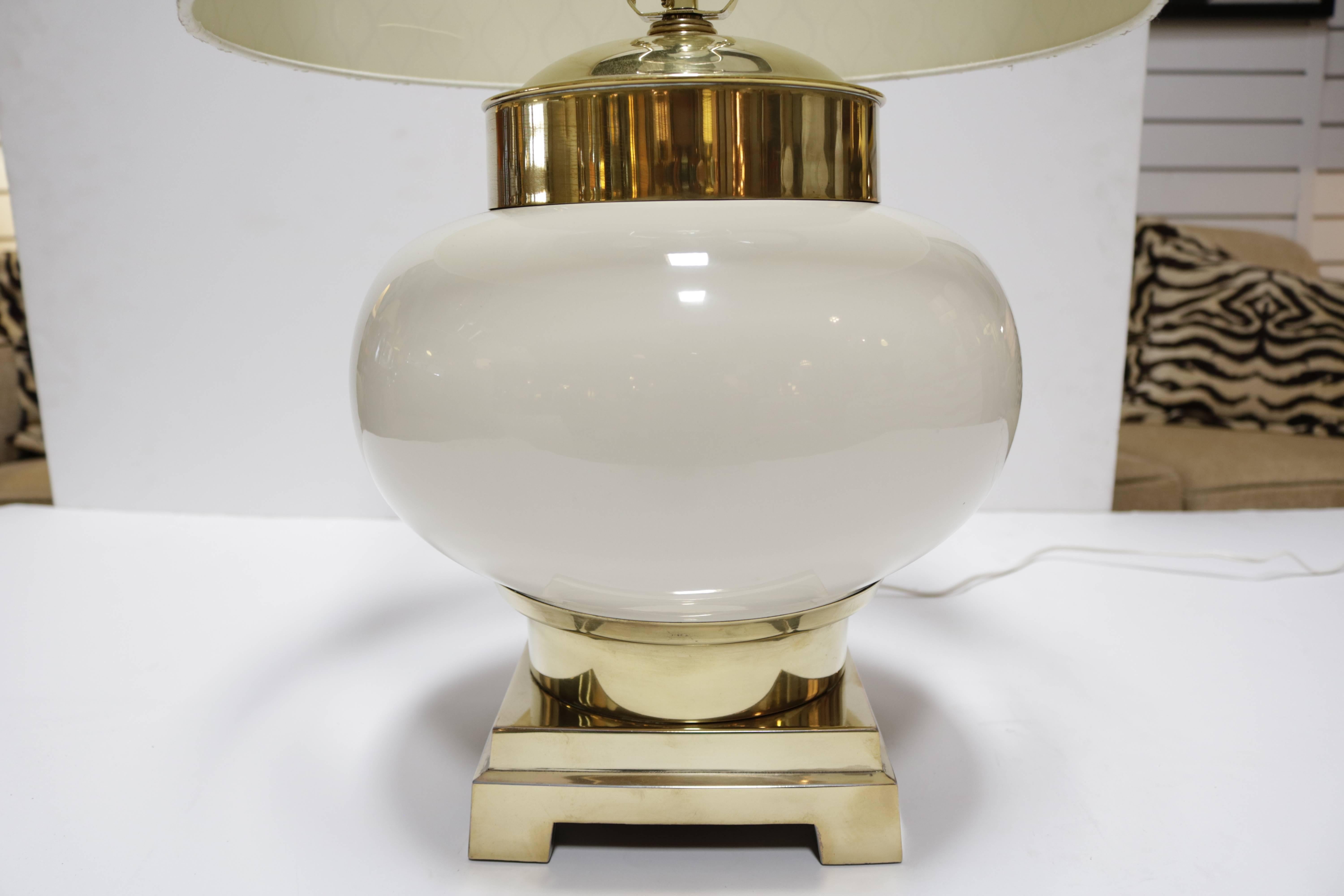 These lamps feature a brass top and base with an ivory ceramic body.