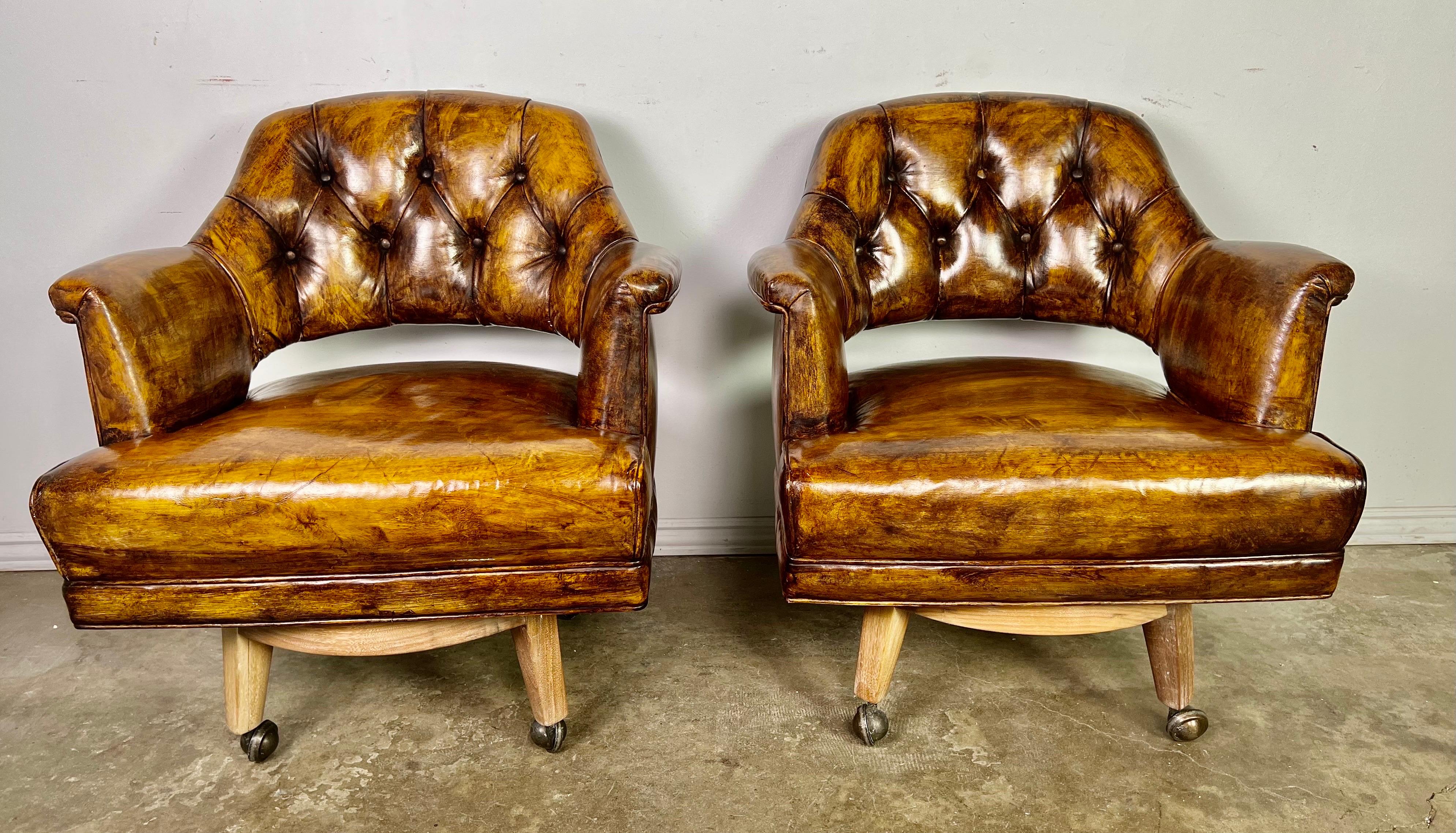Pair of leather tufted mid-century Monteverdi-Young Swivel armchairs. The chair stands on four natural wood legs attached to a swivel mechanism. The chairs are on casters as well. We have four chairs available if needed.
