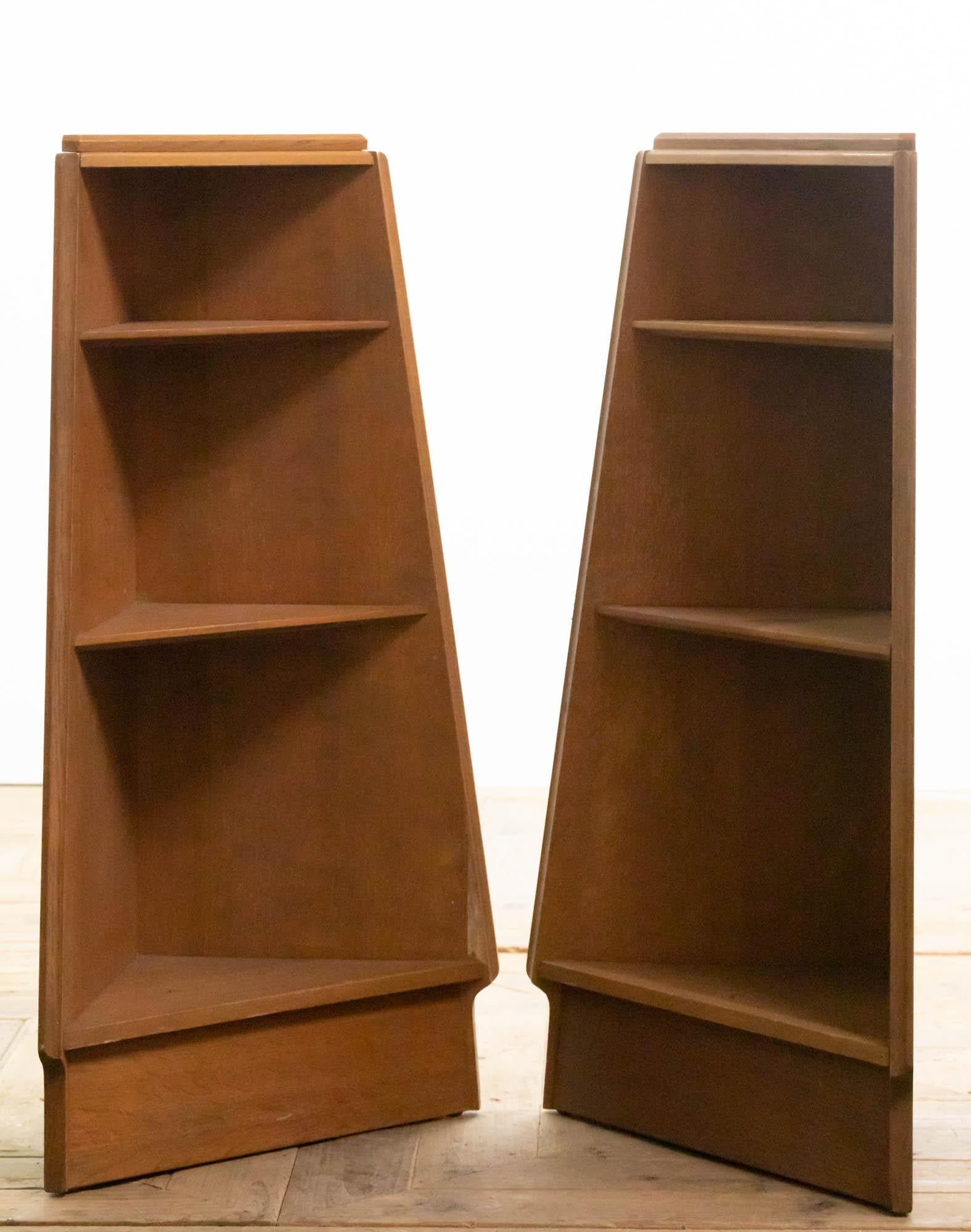 A stunning pair of midcentury limed oak book cases or cabinets in the style of Heals. The tapered triangular design holds three fixed graduated shelves.