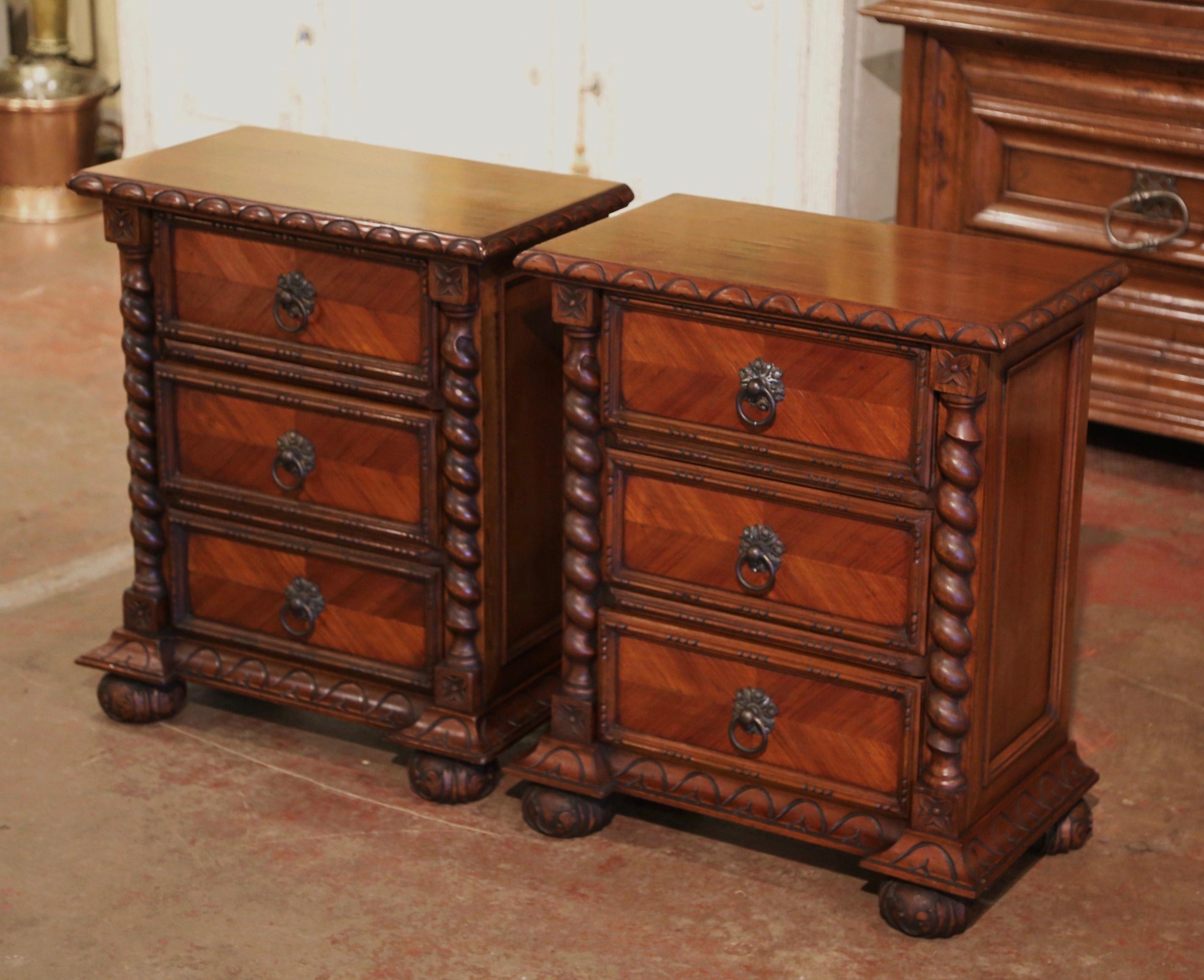 Decorate a master bedroom with this elegant pair of Baroque nightstands. Crafted in France circa 1950, each fruit wood chest stands on bun feet over a carved molded base ending with bracket corners. Each cabinet is dressed with barley twist pilaster