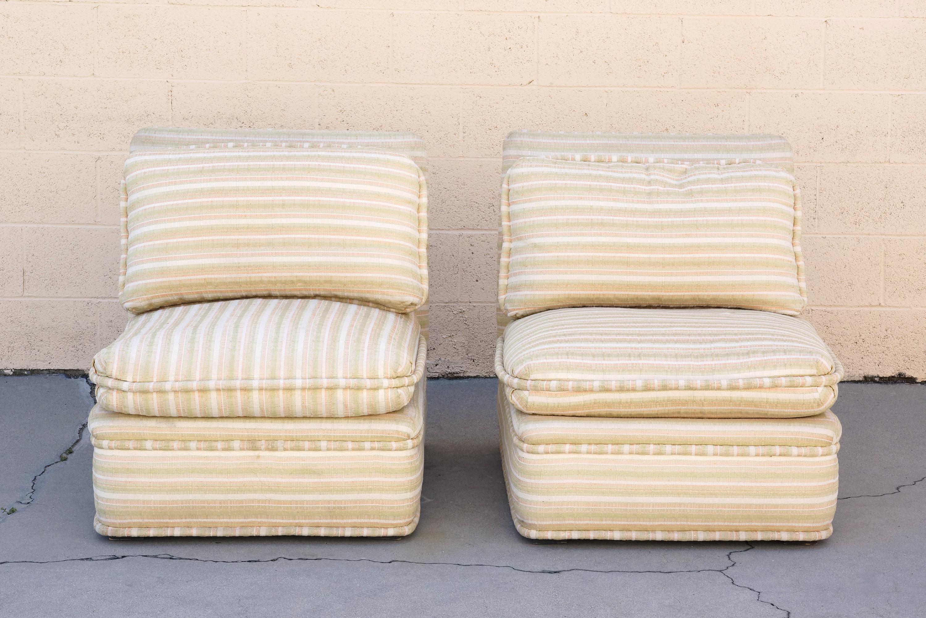 Pair of fantastic midcentury lounge chairs by the historic furniture and interior designers and Cannell and Chaffin of Los Angeles. Plush, armless design with original striped fabric. Upholstery is in excellent condition for age and use and shows