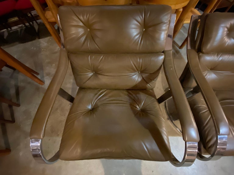 Pair of mid-century lounge chairs designed by Gardner Leaver for Steelcase features brown leather and stainless steel frame and base. Lounge chairs are in overall good condition.