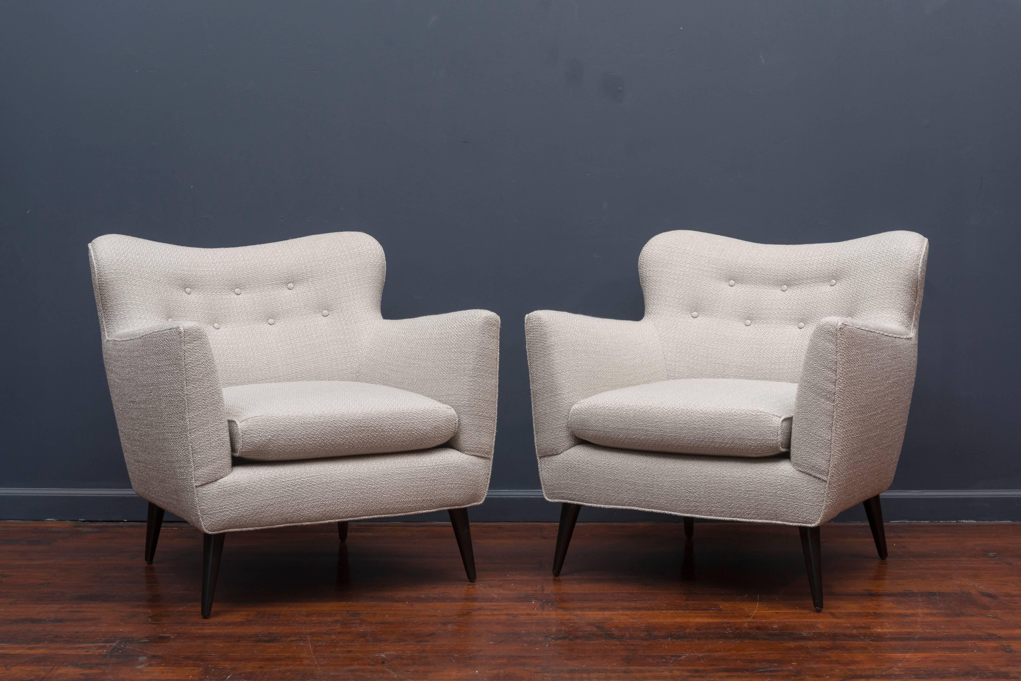 Super pair of mid century lounge chairs newly upholstered in a knobby light silver blend with refinished black lacquer conical legs. Very luxurious and comfy!