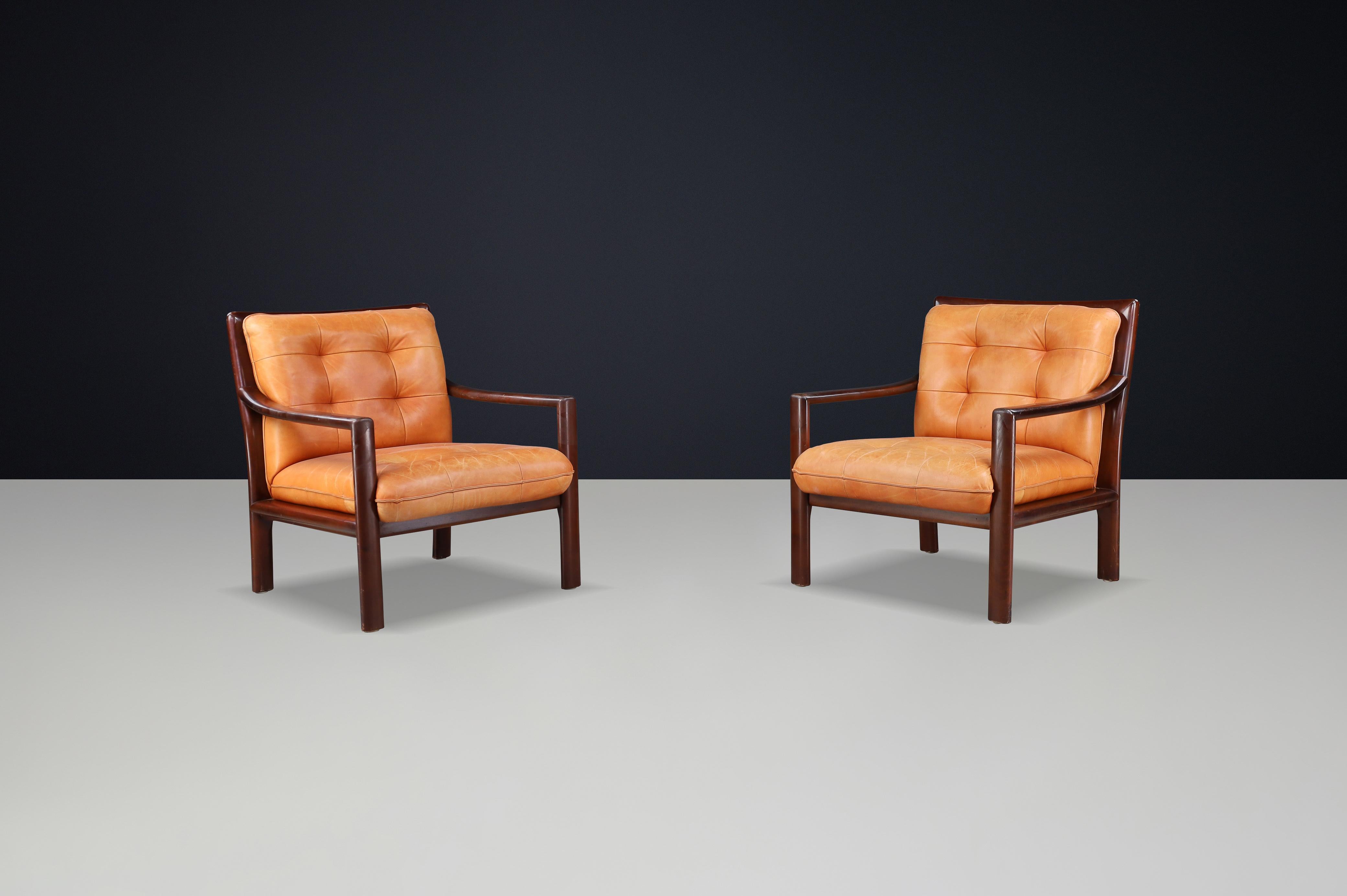 Coppia di sedie da salotto di metà secolo in pelle cognac e legno duro tinto mogano, anni '60 - 2 set disponibili, prezzo per coppia

Questa raffinata coppia di sedie da salotto di metà secolo esemplifica la sobria eleganza e il comfort del