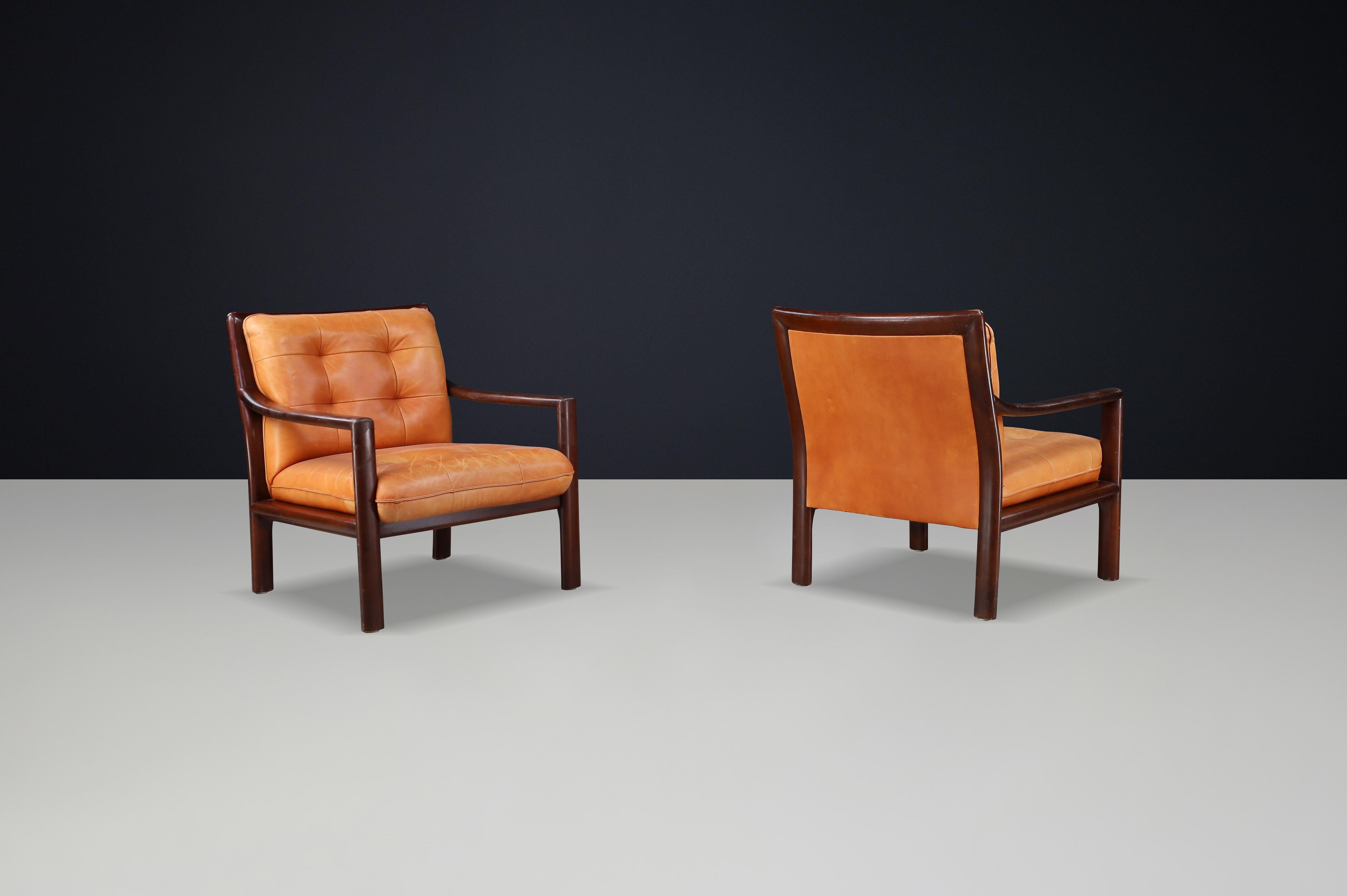 XX secolo Coppia di sedie da salotto di metà secolo in pelle cognac e legno duro tinto mogano in vendita