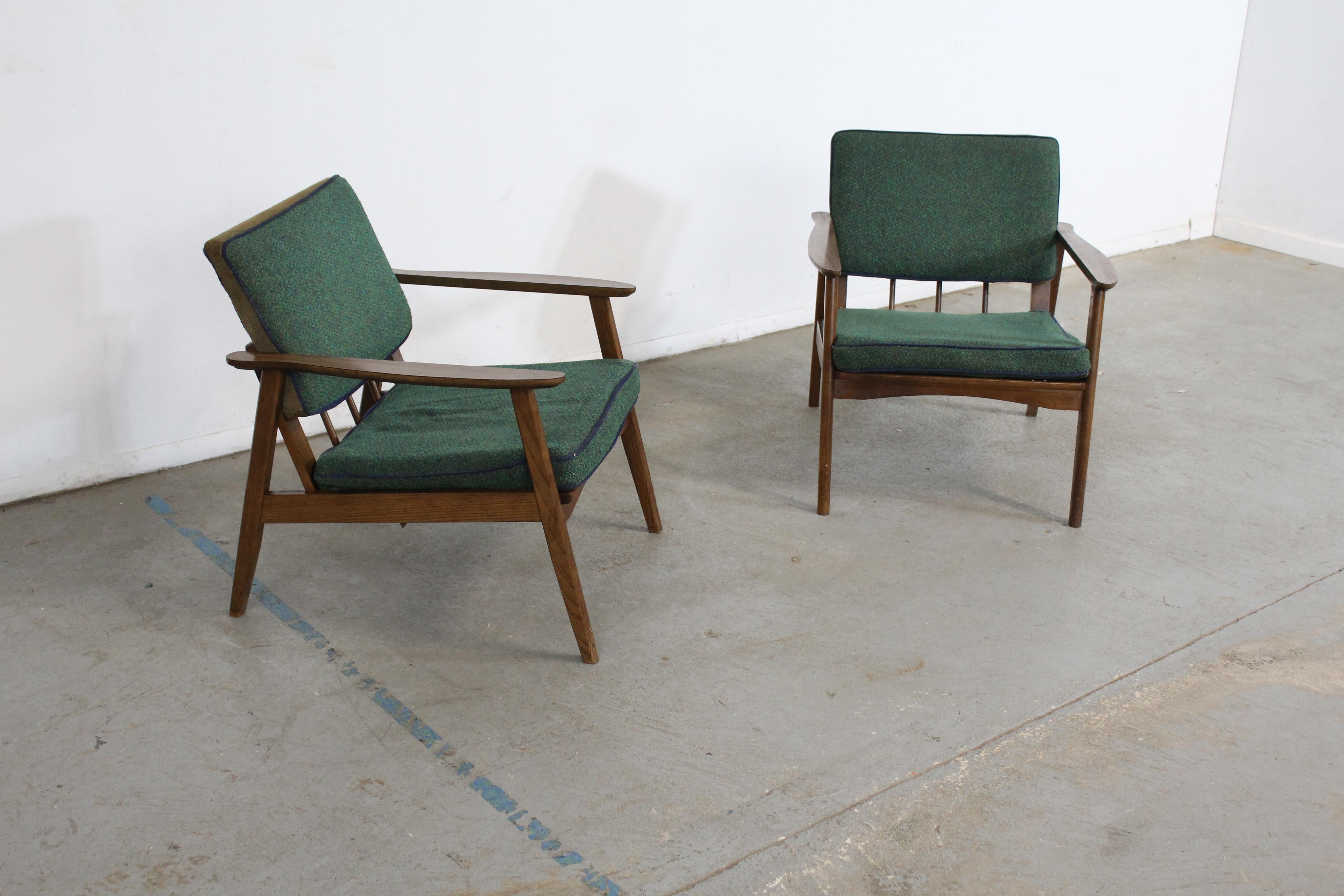 Pair of mid-century lounge chairs walnut open arm lounge chairs

This set includes 2 open arm walnut lounge chairs. The arms feature a laminate top. They need to be reupholstered. The chairs are in good condition, showing minor age wear (cushions