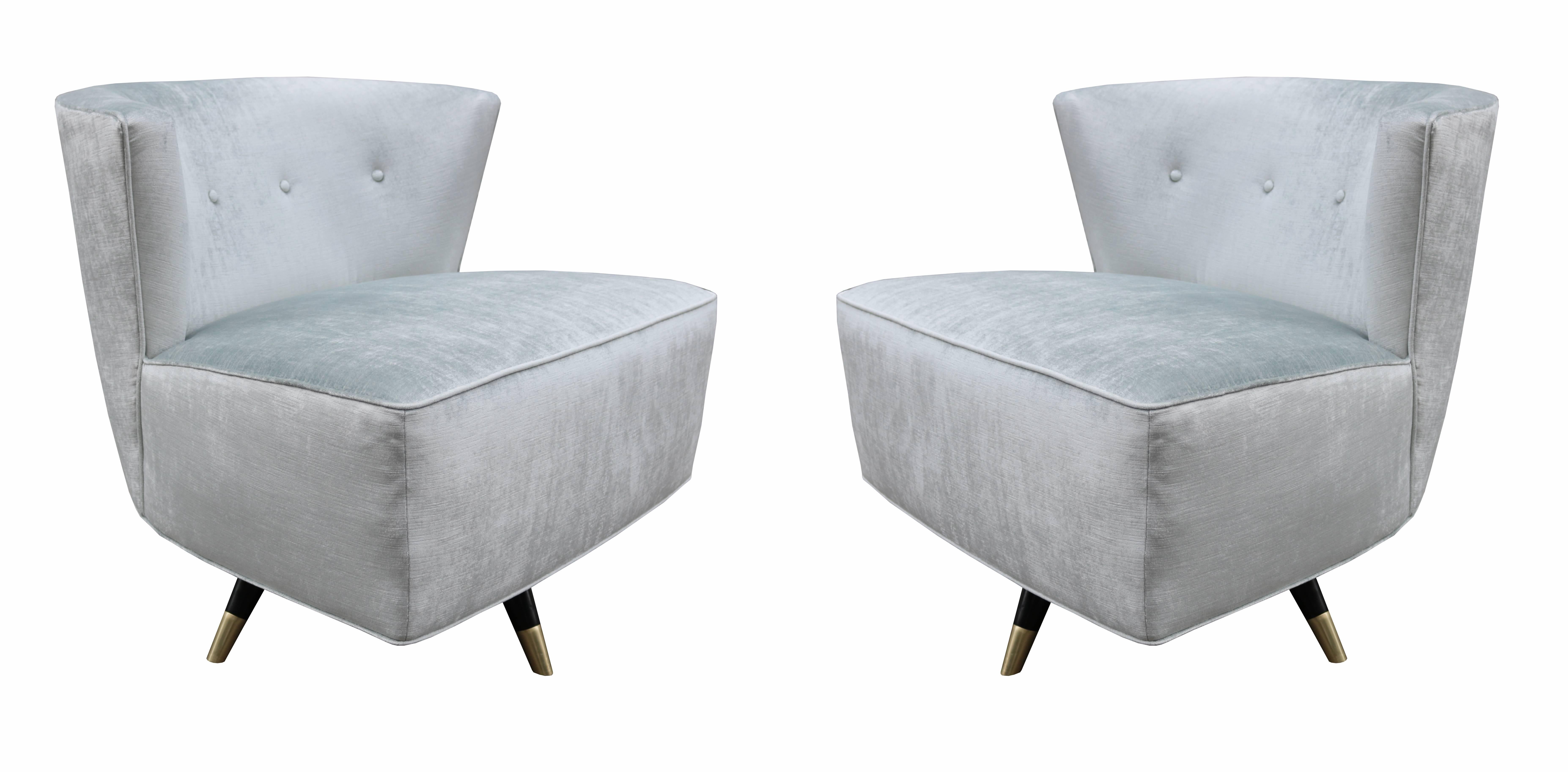 A pair of midcentury low swivel chairs.
Upholstered with ebonized legs 
and patinated brass sabots.
Completely restored.